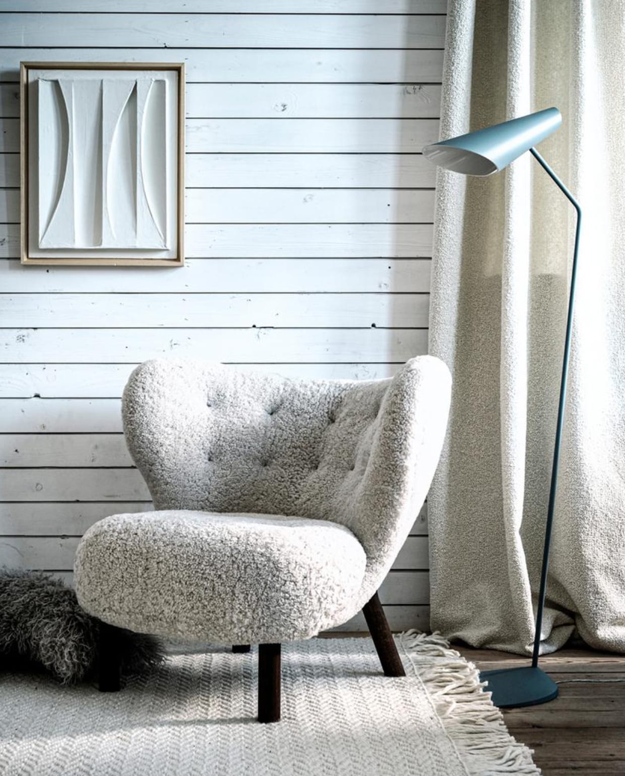 Witte fauteuil in bouclé stof (mobilia.nl). Vloerkleed (vtwonen.nl). Vloerlamp, 127×38 cm (hxb) (homestede.nl). Kunstwerk van Annemieke van Beek, als ruilobject (artinreturn.nl). Kussen (loods5.nl). Vaas met craquelé effect (covanderhorst.nl). Kom op pootje (hkliving.nl). Gordijnstof Frimas in kleur Ivoire van Nobilis (wva.nl). vtwonen 2-2020 | styling Danielle Verheul | fotografie Sjoerd Eickmans