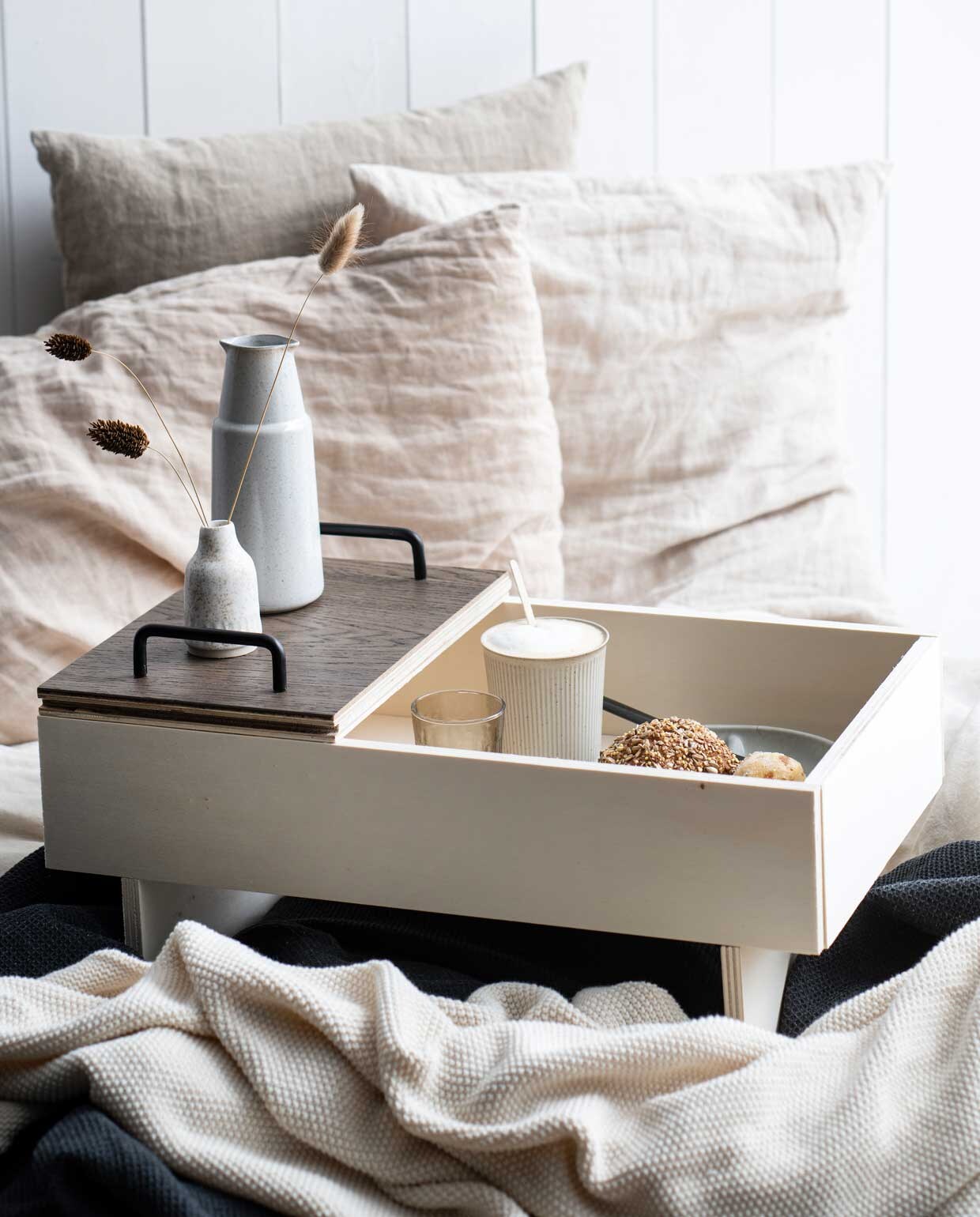 Geribbelde beker Berica € 6,25, glas € 3,50, bordje Branch € 10,95, naturel plaid € 30, donkergrijze plaid Ernst € 49,95, karaf Pion € 16,75, zwart mes € 3,95 (loods5.nl). Vaasje € 22 (zaanschfaamwebshop.nl). Achterste kussen Aina € 7,99 (ikea.nl). Naturelkleurig linnen kussen rechts € 15 (puurlifestyle.com). Overig privébezit.
