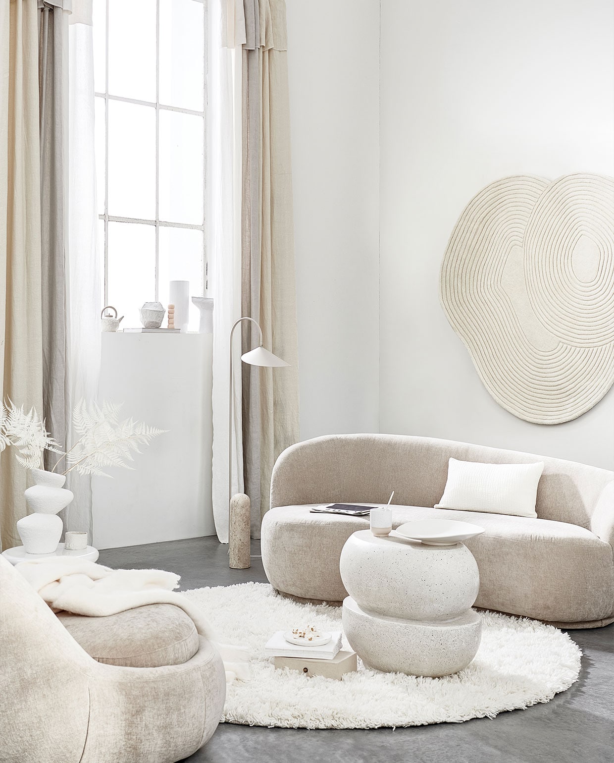 Fauteuil, 176x100x74 cm (bxdxh) € 599,-, bank € 999,- (sofacompany.com). Gordijnen gemaakt van linnen stof Brera Lino in kleur Calico, Putty en Oyster van Designers Guild, per meter € 86,- (wva.nl). Vloerkleed van Linie Design € 700,-, witte bijzettafel van Pols Potten € 294,99, vloerlamp van Ferm Living € 679,- (vtwonen.nl). Wollen plaid € 119,-, keramieken theepot € 25,99, wit kussen € 39,99 (zarahome.nl). Witte keramieken vaas € 29,99 (hm.com). Witte keramieken mok € 22,90 (letoile.store). Geometrische vaas en schaal op voet prijs op aanvraag (julyadrichem.com). Handgemaakte bolletjeskaars, set van drie € 45,- (sukha.nl). Witte porseleinen vaas € 87,-, vloerkleed aan wand € 630,-, witte keramieken mok met ongeglazuurde onderkant, set van twee € 27,- (bolia.com). Betonnen bijzettafel € 450,- (lanena-home.com). Witte keramieken schaal € 44,95 (urbannatureculture.com). Overig privébezit. vtwonen 06-2022 | styling Danielle Verheul | fotografie Sjoerd Eickmans | assistentie Sanne Ketelaar, Minke van Bakel