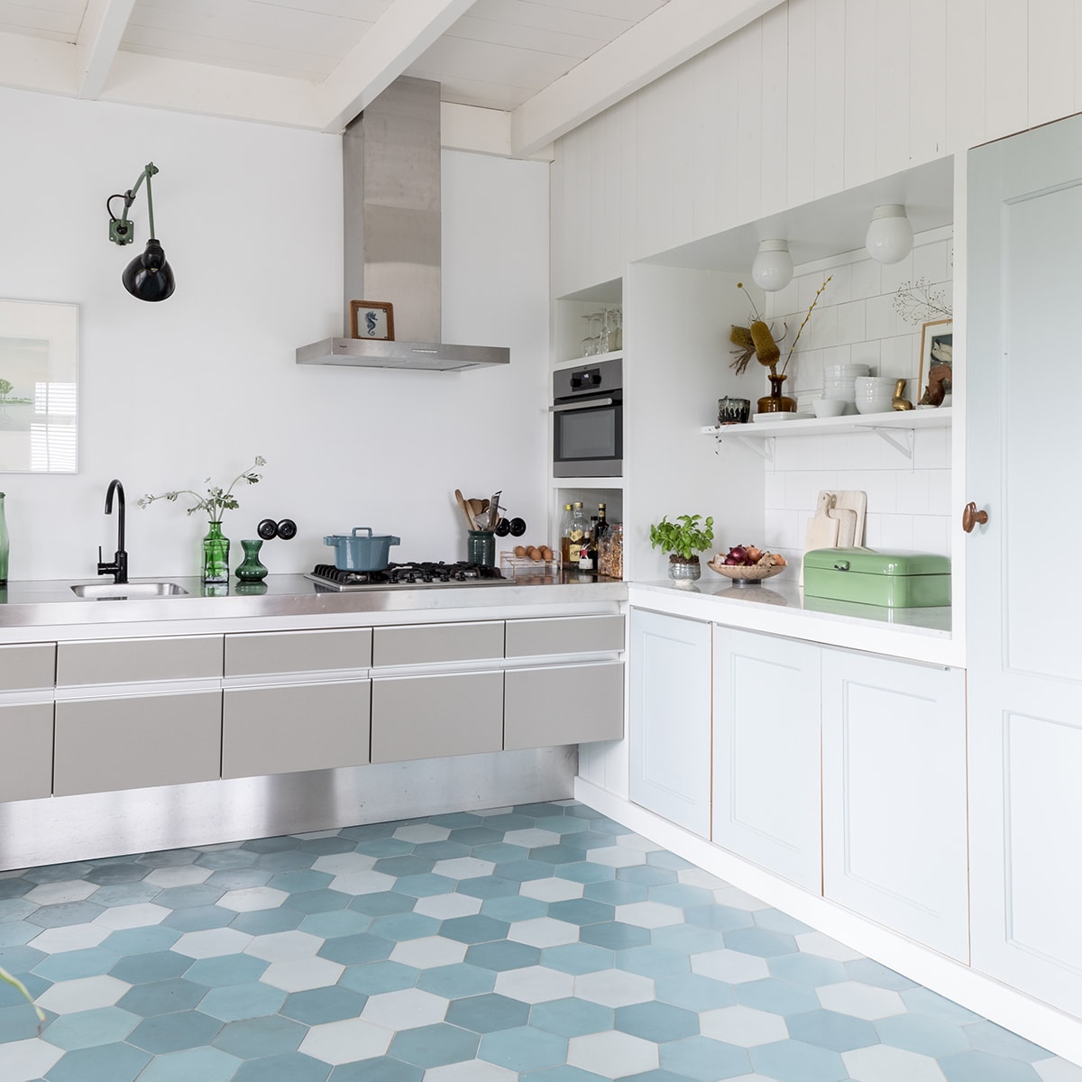 Glanzende wandtegels Praxis. Fruitschaal Marktplaats, emaillen broodtrommel rommelmarkt, roze waterkoker Stelton. Pot en fles op plank Sip &amp; Clara Pop-up Store, witte porseleinen bakjes Arzberg. Pelikanen-verzameling uit Belize, New York en Hemelum. Vintage porseleinen plafondlampen Wilhelm Wagenfeld. vtwonen DIY special 01-2020 | styling Sabine Burkunk | fotografie Hans Mossel