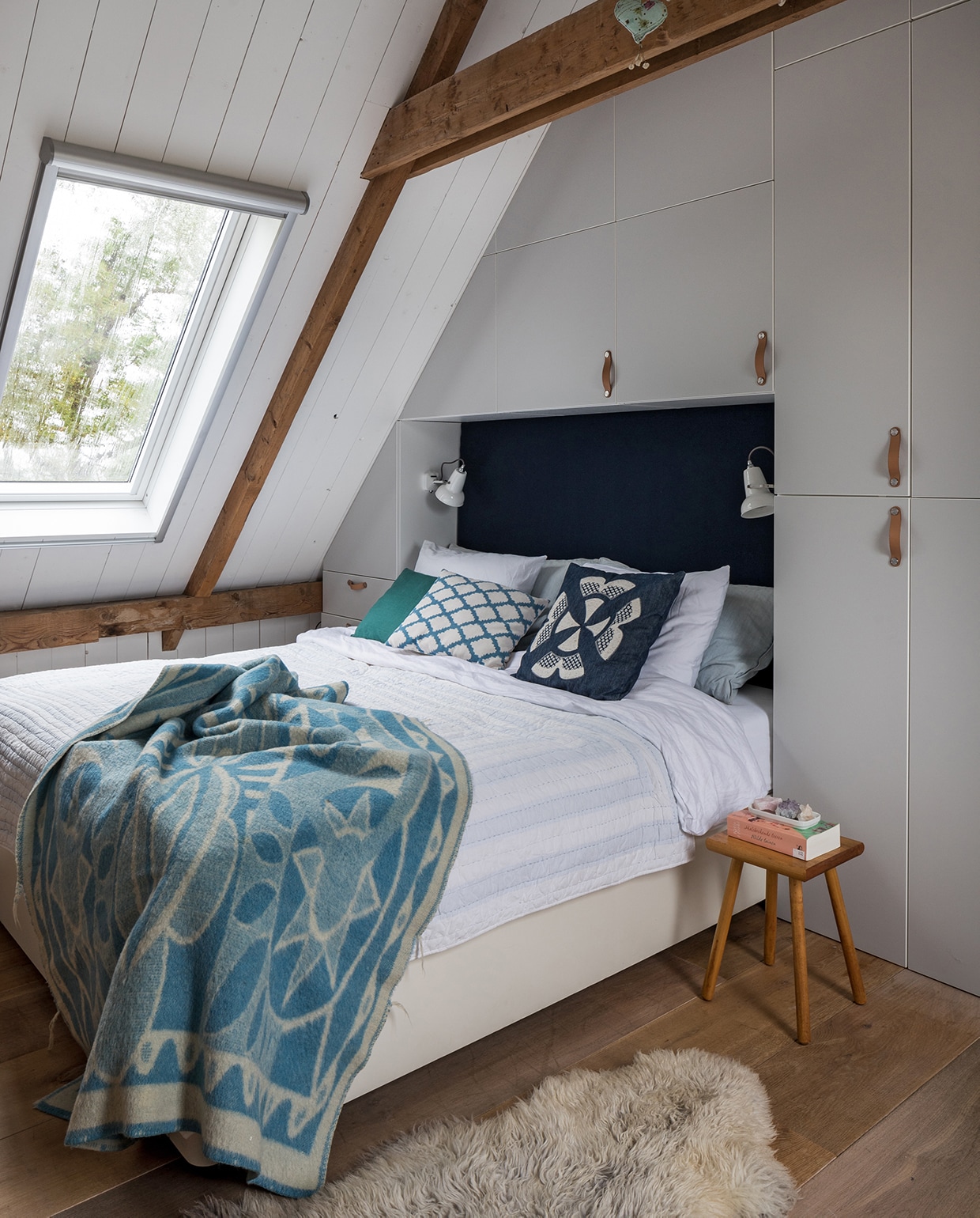 Kasten Ikea. Lampen Anglepoise. Vintage deken AaBe, lichtblauwe sprei Sissy-Boy Homeland. Herkomst donkerblauw en wit kussen onbekend. Groene kussens en melkkruk Sip &amp; Clara Pop-up Store. Schapenvacht Van Buren Bolsward. De mobile is zelfgemaakt. vtwonen DIY special 01-2020 | styling Sabine Burkunk | fotografie Hans Mossel