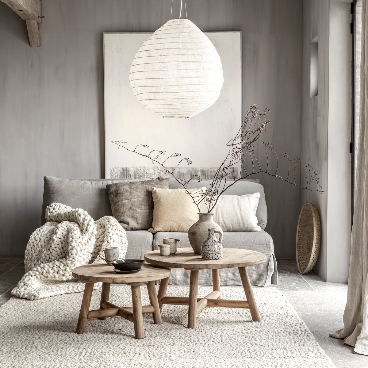 Kalkverf kleur Wet Sand (pure-original.nl). Fauteuils (privébezit) bekleed met hoezen van stonewashed linnen (loggerewilpower.com). Grof gebreide plaid (woondock.nl). Kussen Stone 60×60 cm, gordijnen van linnen (mlfabrics.nl). Zandgeel kussen 50×50 cm, offwhite linnen kussen 40×70 cm, salontafel, kleine salontafel, vloerkleed van 100% wol (hetkabinet.nl). Hanglamp van stof, bamboe schaal (loftloft.nl).