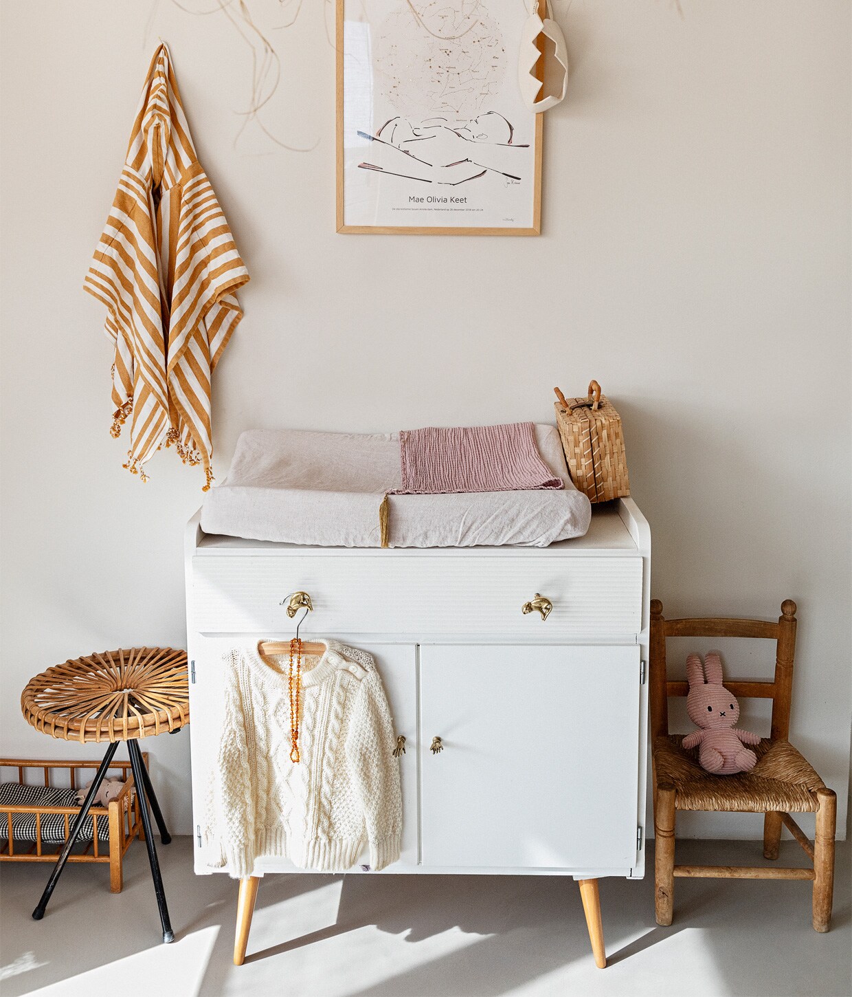 Muurverf Papyrus van Gamma, gietvloerNature Grey. Hanglamp Couleur Locale,kunst aan muur MrStarsky, strandponchokind Liewood. Vintage commodeMarktplaats, deurknoppen Doing Goods.Poppenbed en kruk van Dirk van Sliedregtvintage. Kinderstoel erfstuk Robertsfamilie. Rieten koffer kringloop, jutenkroon Suussies, naturel kroon en rozedeken Archive Store. vtwonen 13-2020 | Styling Ilona Jongepier | Fotografie Dana van Leeuwen