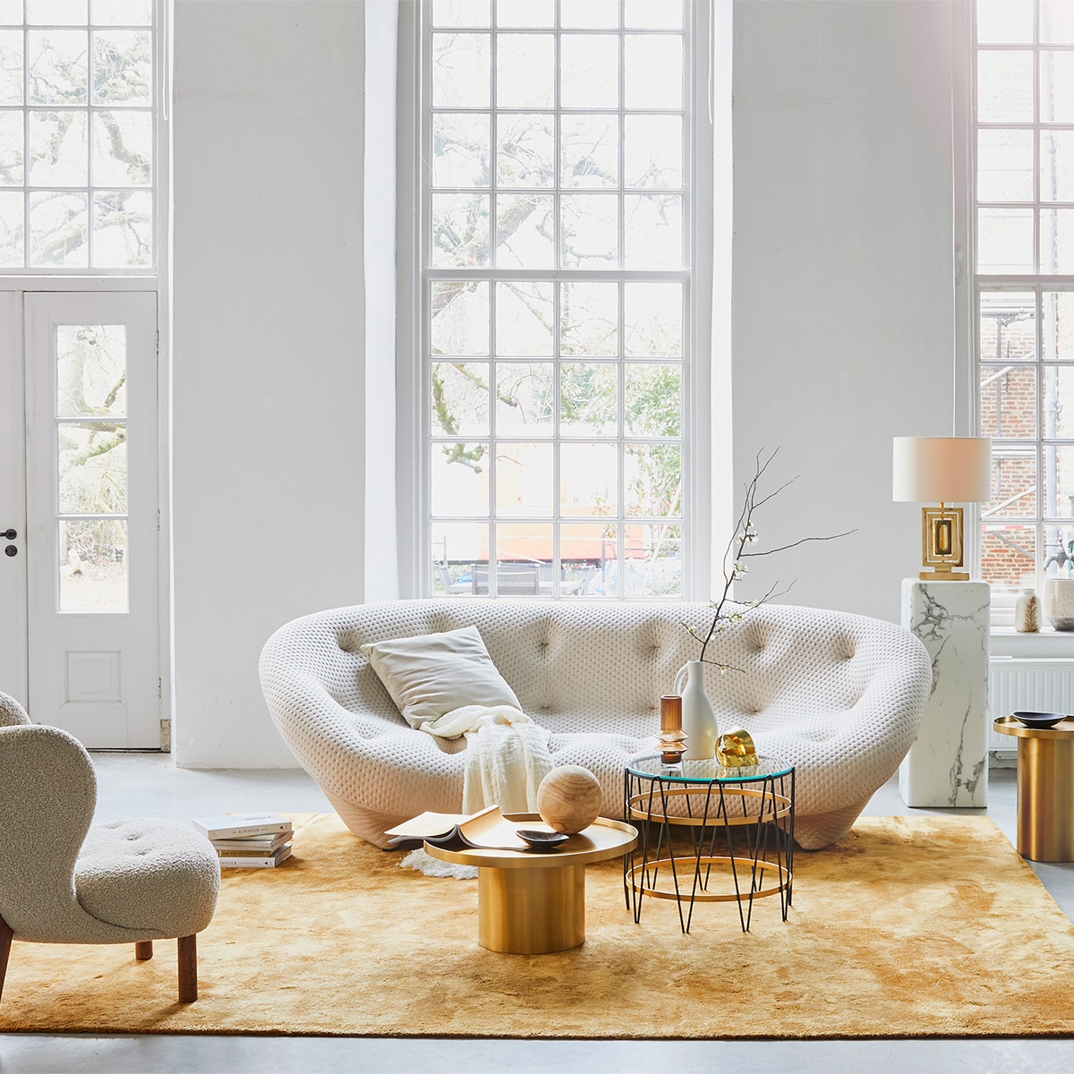 Bank Aikon Lounge, inclusief armsteun (designonstock.com). Vloerkleed van Louis de Poortere uit de serie Mad Men (vloerkledenwinkel.nl). Salontafel marmerlook, 40,6×100 cm (hxØ), rond kussen, goudkleurig velvet kussen (polspotten.nl). Loungestoel velvet, plaid , witte vaas met oor, kleinere vaas van Loods 5 Design (loods5.nl). Hoge vaas, staande lamp (hkliving.nl). Beige Poef Sandared, grijze poef, lijst Hovsta (ikea.nl). Lamp op marmeren schouw (maisonnl.com). Lamp in vensterbank (dutchbone.com). Vaas met oren (neeflouis.nl). Kandelaar op tafel (vtwonen.nl). Overigprivébezit. JA | vtwonen 02-2019 | styling Cleo Scheulderman | fotografie Jeroen van der Spek
