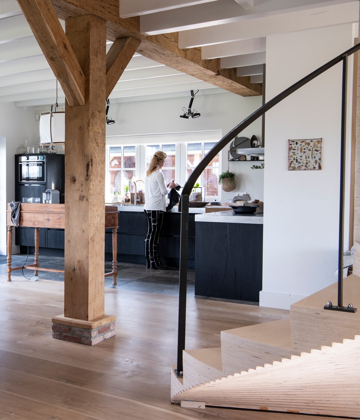Licht eiken plankenvloer in drie breedtes Dennebos Flooring, trap ontworpen door Buro Logge in samenwerking met Westenwolf Trappen. Balkenconstructie oude onbehandelde eiken balken Frank Pouwer, vazen Tica, verf op de muur Persian Grey van Painting the Past. Oude houten commode is privébezit. vtwonen 13-2020 | Productie Insidehomepage | Styling Marlies Does | Fotografie Louis Lemaire| Tekst Cathelijne van Wingerden