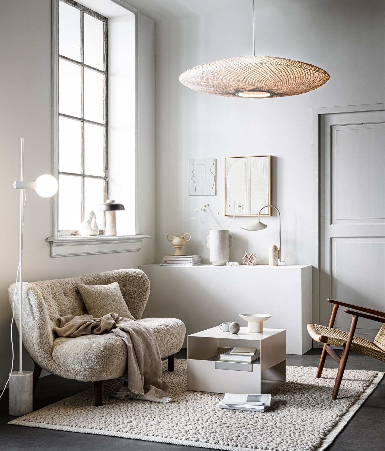 Bank Little Petra van &amp;Tradition, walnoothouten poten en sheepskin Moonlight bekleding, 150x80x75 cm (bxdxh) € 6183,- (andtradition.com). Fauteuil CH25 van Hans J. Wegner, van geolied walnoot met zitting en leuning van geweven papierkoord, € 3629,- (kasstoor.nl). Vloerkleed Gravel Ivory van Menu, 170×200 cm € 810,- (thefinestore.com). Vloerlamp Revolve met marmeren voet, 158,5 cm hoog, bol van opaalglas 13,5 cm (Ø) € 459,-, kussen 40×40 cm € 136,- (bolia.com). Metalen salontafel Axe, 50x50x35 cm (bxdxh) € 329,- (festamsterdam.com). Tafellamp Reverse van Menu € 550,- (designtales.nl). In het raamkozijn: witte porseleinen boekensteun Boulder van Hay € 75,- (vtwonen.nl). Porseleinen kunstobjecten Sculpture Maida € 90,-, Sculpture Azi Structured € 150,-, vaas in twee delen met twee oren uit serie Earth Vases, per onderdeel van € 30,- tot € 57,50, keramieken schaal op voet Moon Totem € 190,-, kunstwerk Mirrors met eikenhouten lijst € 500,-(studio-yen.com). Linnen plaid, 140×190 cm € 79,99 (zarahome.com). Aardewerken vaas met oren van Urban Nature Culture € 49,99 (sissy-boy.com). Tafellamp Arum van Ferm Living, marmeren voet en gepoedercoat staal, 20,5x50x34 cm (bxhxd) € 405,- (fermliving.com). Bamboe hanglamp Ufo, 21×82 cm (hxØ) € 495,-, wit aardewerken kunstwerk 26,6×23,5 cm € 49,95 (hkliving.nl). Espressomok met oor , € 4,25 (loods5.nl). Overig privébezit. vtwonen 13-2020 | Styling Kim van Rossenberg | Fotografie Sjoerd Eickmans