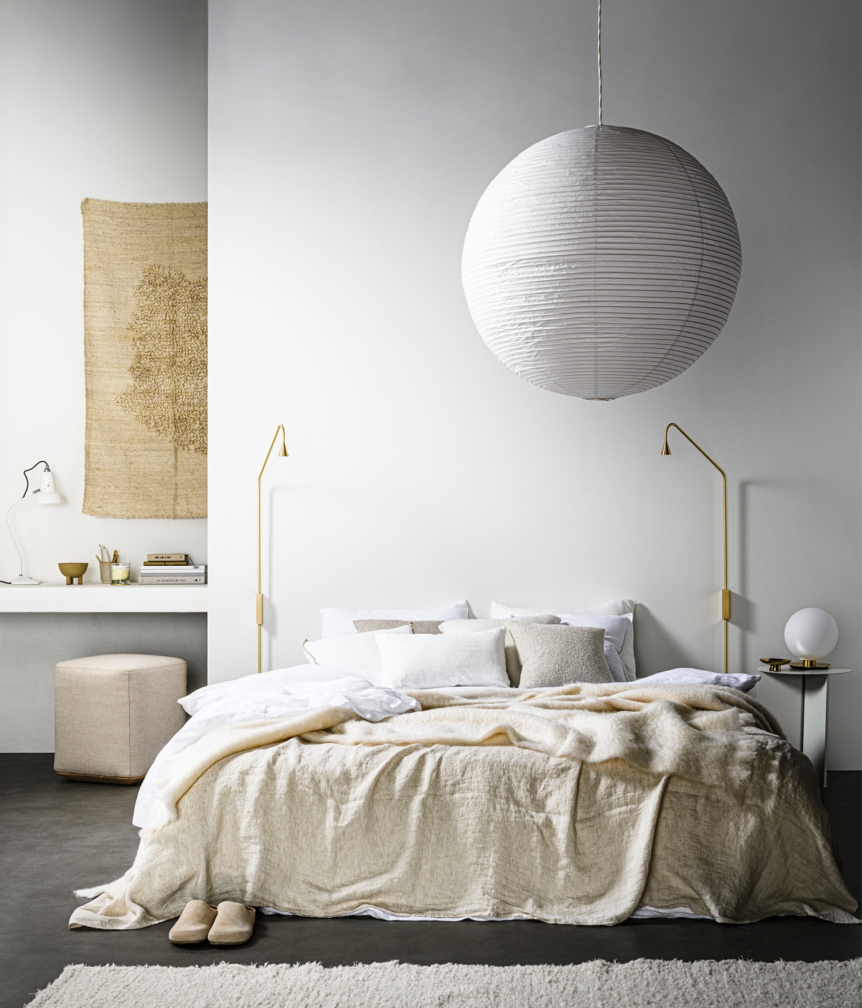 Rijstpapieren lampenkap van Hay, 80 cm (Ø) € 39,-, bureaulamp met doorschijnende porseleinen kap Original 1227 Mini Ceramic Table lamp by Anglepoise, 14×13 cm (hxØ) , € 180,- (thefinestore.com). Schapenwollen wandkleed Isla Rug, 140×85 cm € 325,- , (studio-yen.com). Schaal op pootjes Duck , € 20,- (101cph.com). Beker € 6,25 (loods5.nl). Geurkaars € 15,99, leren sloffen € 35,99, vloerkleed 160×230 cm € 99,99, kussen met beige rand, 45×45 cm € 19,99, wit linnen kussen, 30×50 cm 22,99 (zarahome.com). Vierkante poef Otto S, 40×40 cm, in stof Hallingdal 200 en eiken basis vanaf € 350,-(studio-henk.nl). Stalen ronde bijzettafel Slit van Hay, 47×35 cm (hxØ) € 159,-, bollamp van opaalglas op voet van geborsteld messing uit TR collection van Menu, geschikt als wand-, plafond- en tafellamp, 22×20 cm (hxØ) , € 259,40 (vtwonen.nl). Messing wandlamp Austere van ontwerper Hans Verstuyft, 120×40 cm, per stuk vanaf € 695,- (trizo21.com). Goudkleurige schaal op voet € 7,99, linnen badjas € 39,99 (hm.com). Beige kussen , 40×40 cm € 136,-, wit linnen kussen 50×50 cm € 47,-, beige kussen 50×50 cm € 111,-, kussen Ivory 50×50 cm € 121,- (bolia.com). Linnen beddengoed Pure White, 240×220 cm € 249,-, linnen laken Pure White, vanaf € 129,-, linnen kussenslopen, 60×70 cm € 30,-, linnen plaid Sea Shell, 145×270 cm € 149,-, mohair deken Chalk, 130×200 cm € 199,- (bymolle.com). Overig privébezit. vtwonen 13-2020 | Styling Kim van Rossenberg | Fotografie Sjoerd Eickmans