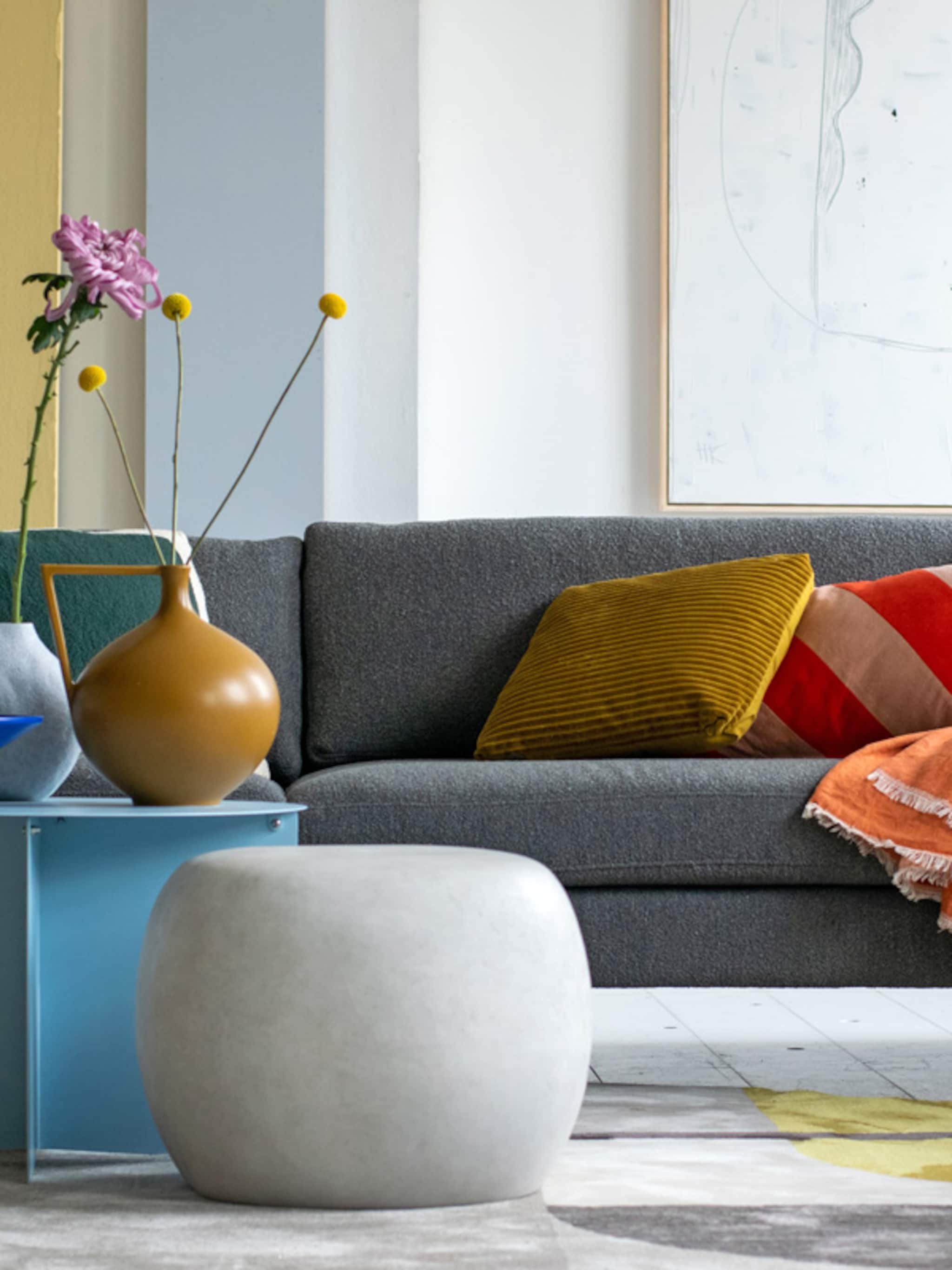 stylingtips van marianne kleur geven aan de grijze bank