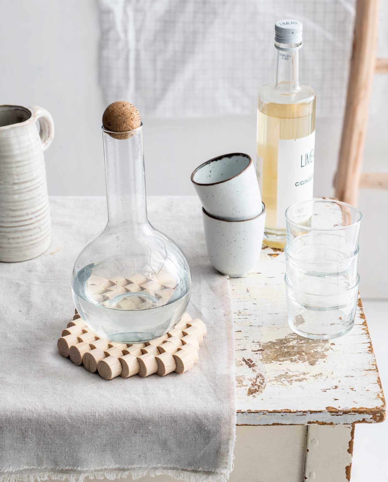 Glaasjes Bodega per stuk € 1,75 (dille-kamille.nl). Mok Emma per stuk € 2,79 (xenos.nl). Limonadefles Limeau Gingerale € 4,10 (ah.nl). Decoratieve ladder Roel teak, 160x55x5 cm (lxbxd) € 39,99 (leenbakker.nl). Tafeltje (vandijkenko.nl). Soortgelijke karaf (blokker.nl). Overig privébezit.