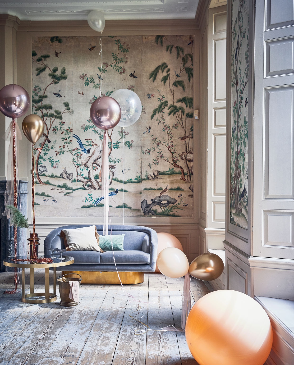 Ballonnen (partyballoon.nl). Tule (boerenbonthal.nl). Franjegordijn (slinger.nl). Glazen salontafel 45×80 cm, vaas, fluwelen kussen met franjes (nordal.eu). Groen kussen, grijze champagneglazen metribbel van Ferm Living(vtwonen.nl). Zilvergrijze fluwelen bank van Jonathan Adler (ankevangoor.com). Champagnekoeler (iblaursen.dk).