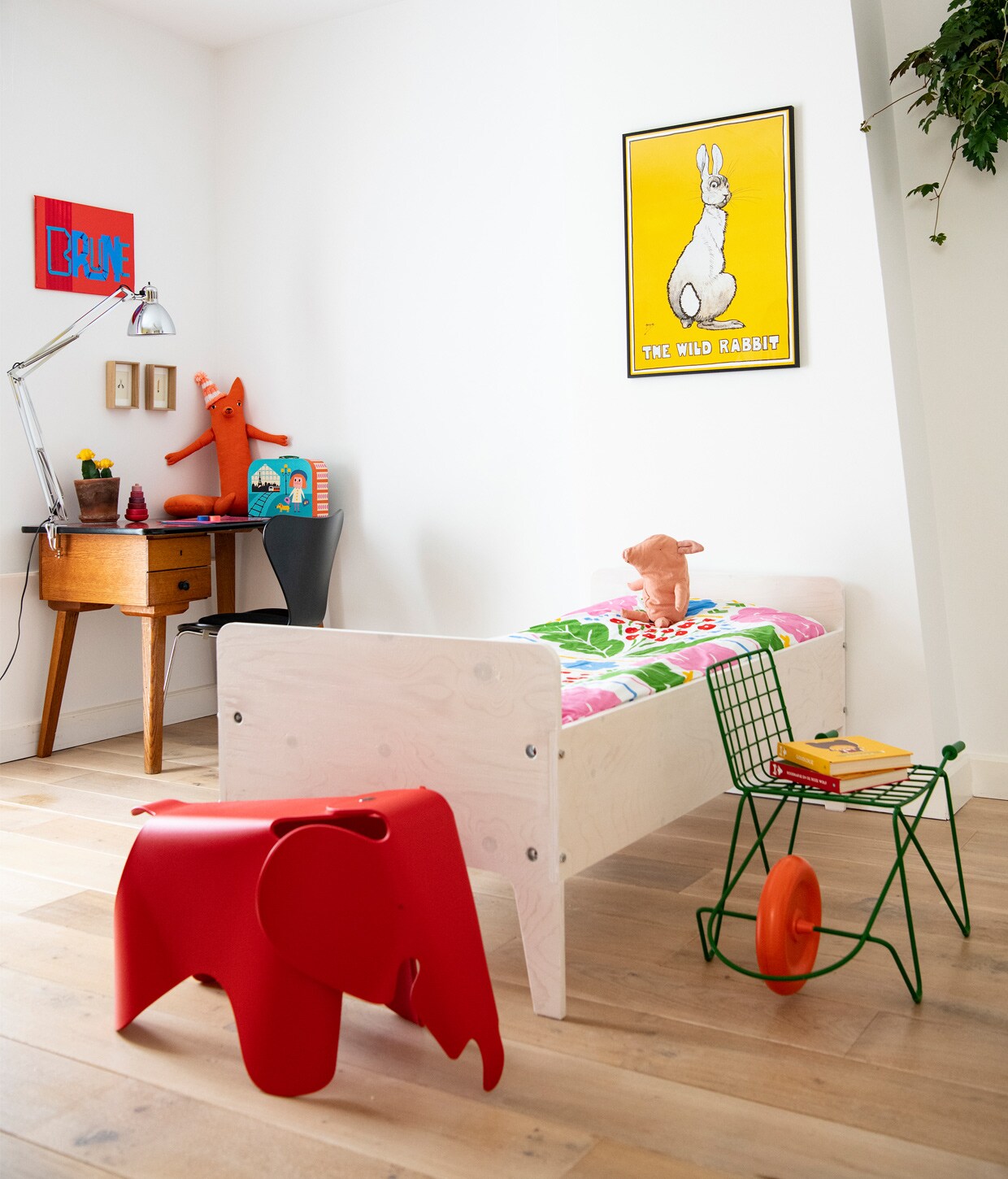 Kunstwerk Brune van Jochem Rotteveel. Bureau vintage, lamp Naska Lora van FontanaArte, knuffel vos Donna Wilson, kartonnen koffer Ingela P. Arrhenius, zwarte vlinderstoel Fritz Hansen. Bed Crisis van Piet Hein Eek, dekbedovertrek Onni van Marimekko, knuffel big Maileg. Poster The wild rabbit via Catawiki. Rijdende kinderstoel Trotter van Magis. Rode Eames-olifant Vitra. vtwonen BK Special 12-2020 | Productie Insidehomepage | Styling Susanne Kennedy | Fotografie Louis Lemaire | Tekst Inge van Lieshout | Tekstbewerking Anna van der Heijden