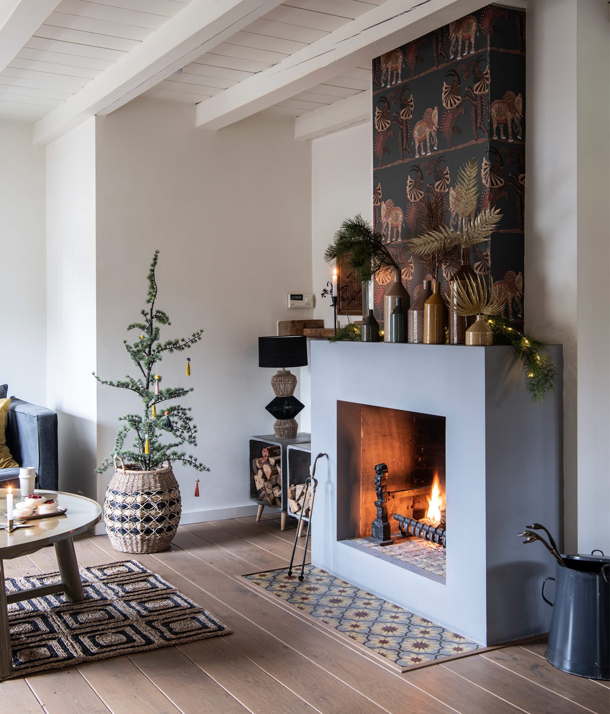 Behang Cole &amp; Son. Tegels Designtegels. Mand, vazen en lamp Madam Stoltz. Kolenkit vintage. Bijzettafels gebruikt om houtblokken in op te slaan Intratuin. Vloerkleed E|L International Deens. Vloer was al aanwezig.