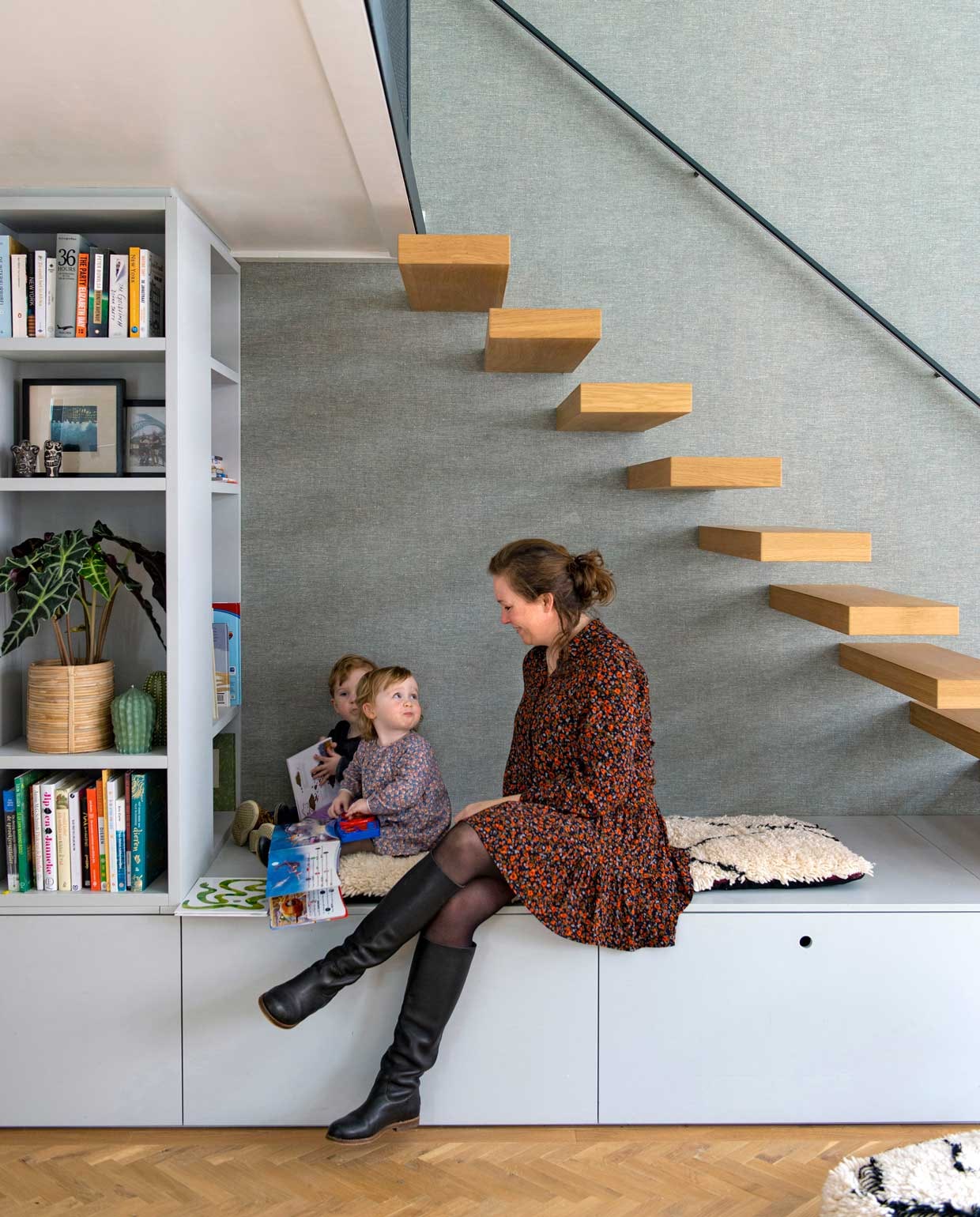 Kasten op maat gemaakt door Fontijn Interieur Projecten. Zwevende eikenhouten trap Decotrap, behandeld met houtolie Monocoat Mist 5%. Behang Bazar 219427 van BN Walls. Kussen gemaakt van reststuk van berberkleed uit Marokko. vtwonen special binnenkijken 12-2020 | Styling Geertje Planken | Fotografie Caroline Coehorst