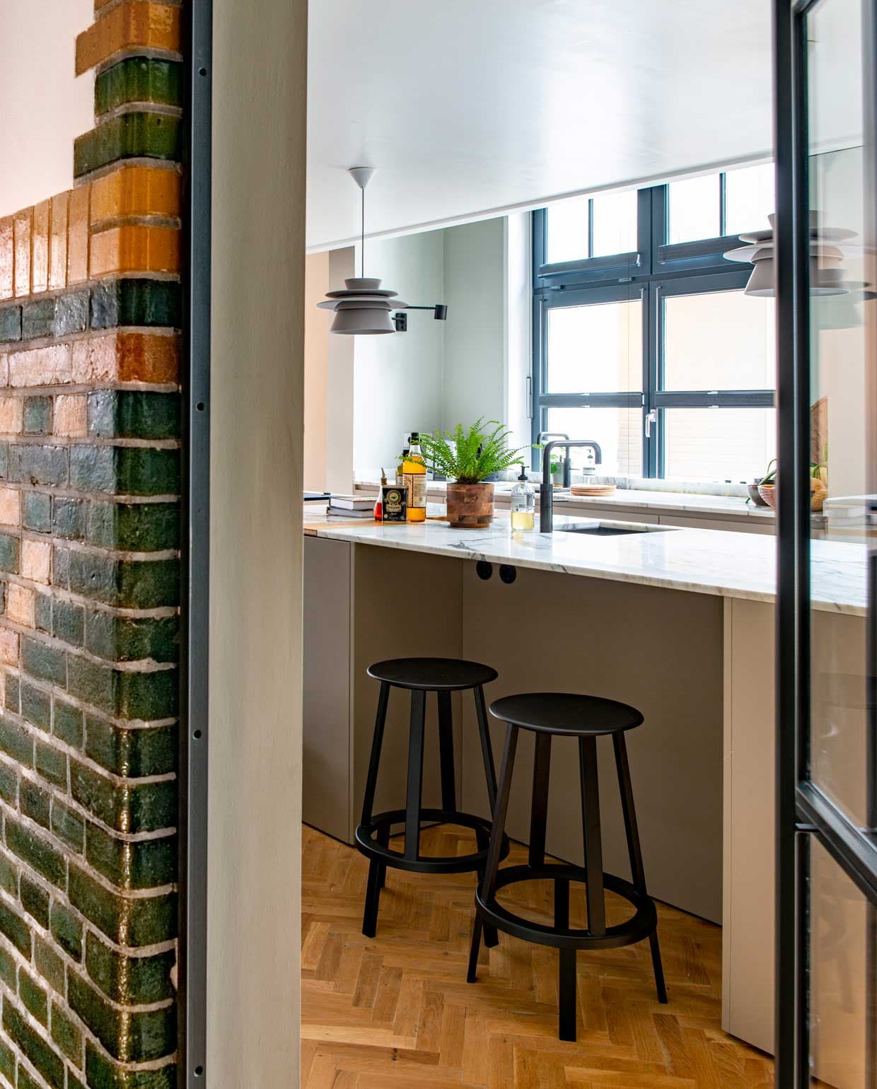 Keuken op maat gemaakt door Fontijn Interieur Projecten. Muurverf Cromarty van Farrow &amp; Ball. Hanglampen Zuperzozial. Marmeren keukenblad Cortlever-Agricola. Rustiek eiken visgraatvloer Floor Inn, behandeld met houtolie Monocoat Mist 5%. Deuren en kozijnen op maat gemaakt door Spilleman. vtwonen special binnenkijken 12-2020 | styling Geertje Planken | fotografie Caroline Coehorst