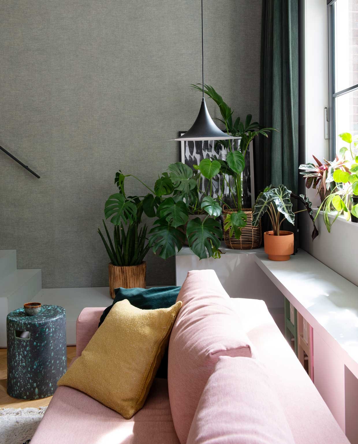 Behang Bazar 219427 van BN Walls. Zwevende eikenhouten trap Decotrap, behandeld met houtolie Monocoat Mist 5%. Ingelijste poster Junique. Vensterbank en kasten op maat gemaakt door Fontijn Interieur Projecten. Hanglampen Malou van Karwei (links) en Mora van Zuiver.Zit-slaapbank Innovation, kussens Karwei en Innovation, wit kussen souvenir uit Marokko. Aardewerken tuinkrukken gebruikt als bijzettafels Made. Stoel Pierre Jeanneret Office Chair via Object Embassy. Kleed Karwei. Planten De Balkonie en Sprinklr, terracotta bloempotten onder andere Sprinklr, Søstrene Grene en H&amp;M Home. vtwonen special binnenkijken 12-2020 | styling Geertje Planken | fotografie Caroline Coehorst