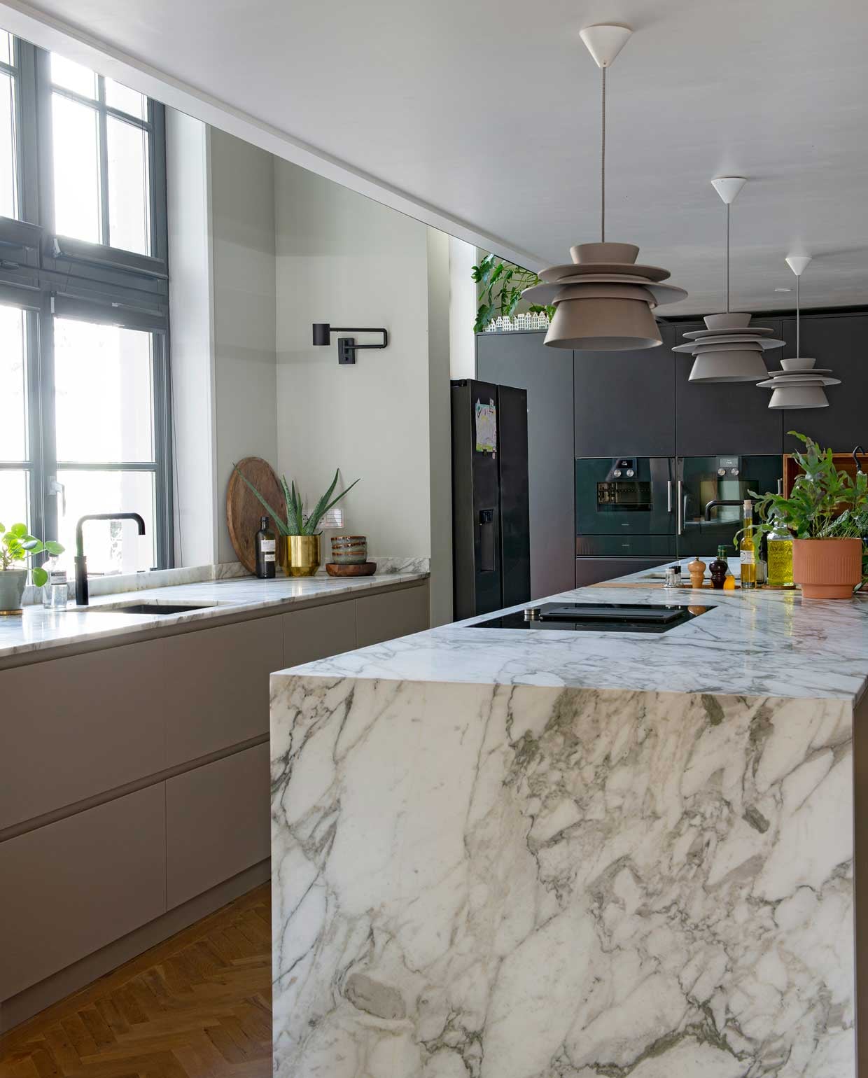 Keuken op maat gemaakt door Fontijn Interieur Projecten. Stalen stellingkast Spilleman. Muurverf Cromarty van Farrow &amp; Ball. Hanglampen Zuperzozial, wandlamp Ikea. Marmeren keukenblad Cortlever-Agricola. vtwonen special binnenkijken 12-2020 | styling Geertje Planken | fotografie Caroline Coehorst