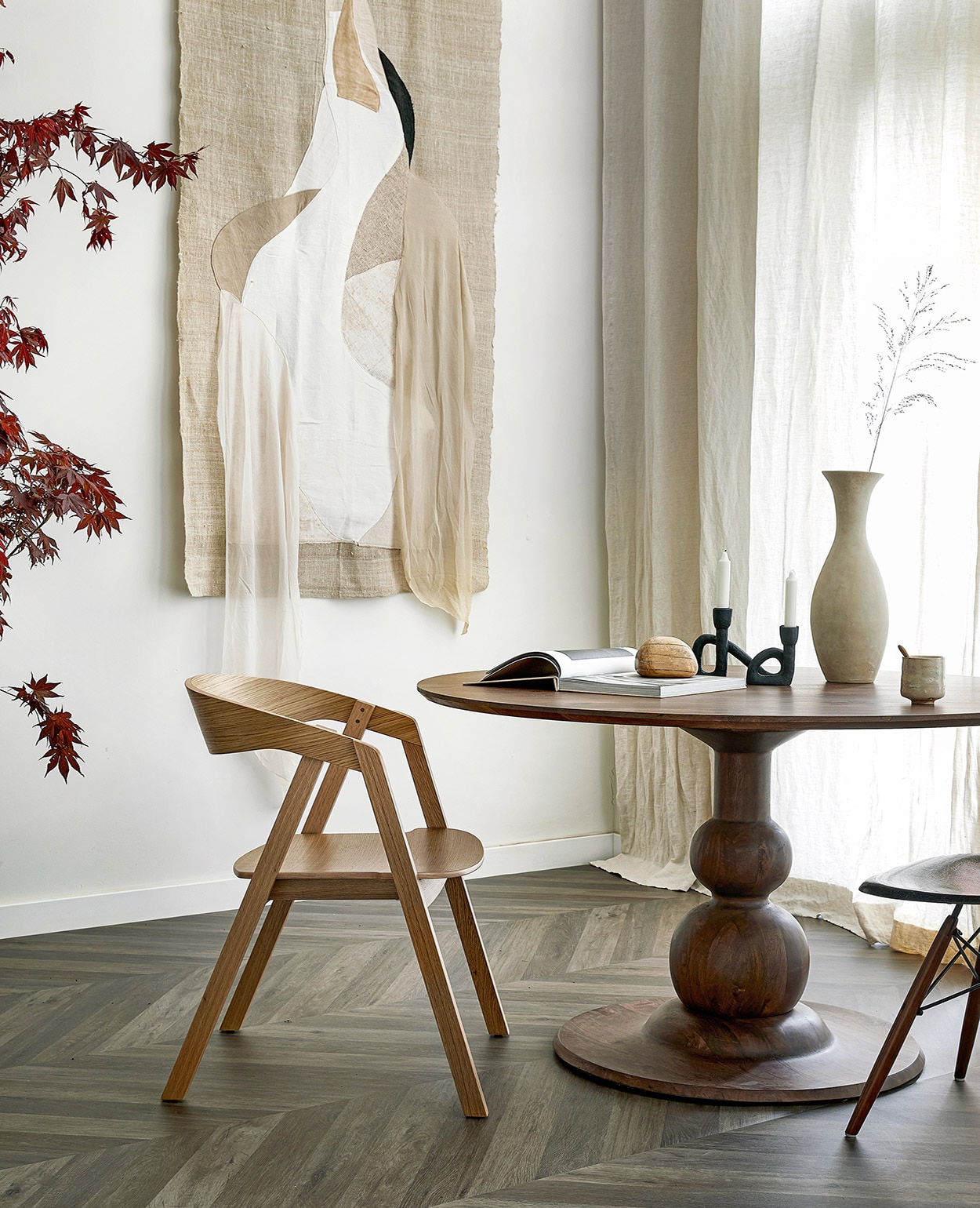 Novilon vloer Zoethout per m² € 29,50.M.m.v. basiclabel.nl (eettafel), demachinekamer.nl (eikenhouten stoel Edske van Sav &amp; Økse, Eames DSW zwarte kuipstoel van Herman Miller), studio-yen.com (zwarte kandelaar, houten kei, boek Bea Mombaers), adrianameunie.wordpress.com (artwork met Japanse kraanvogel, in opdracht van Avenue Design Studio). Overig privébezit. vtwonen 07-2021 | styling Marlies Does | fotografie Peggy Janssen | productie Tanja Saarberg