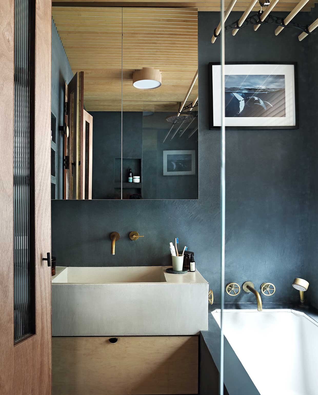 Liefde voor walvissen van de oudste dochter inspireerde bij het inrichten van de badkamer. De kleur van de tadelakt baseerden zij op walvisgrijs, gemengd via Tadelakt London. Bad en wastafel van Rise Design Studio, net als de kastjes, gemaakt door Liam Dryden. Kranen The Watermark Collection. Schilderij Natural History Museum. NEE | vtwonen binnenkijken special 03-2020 | styling: someday studio | fotografie: Elsa Young/bureaux