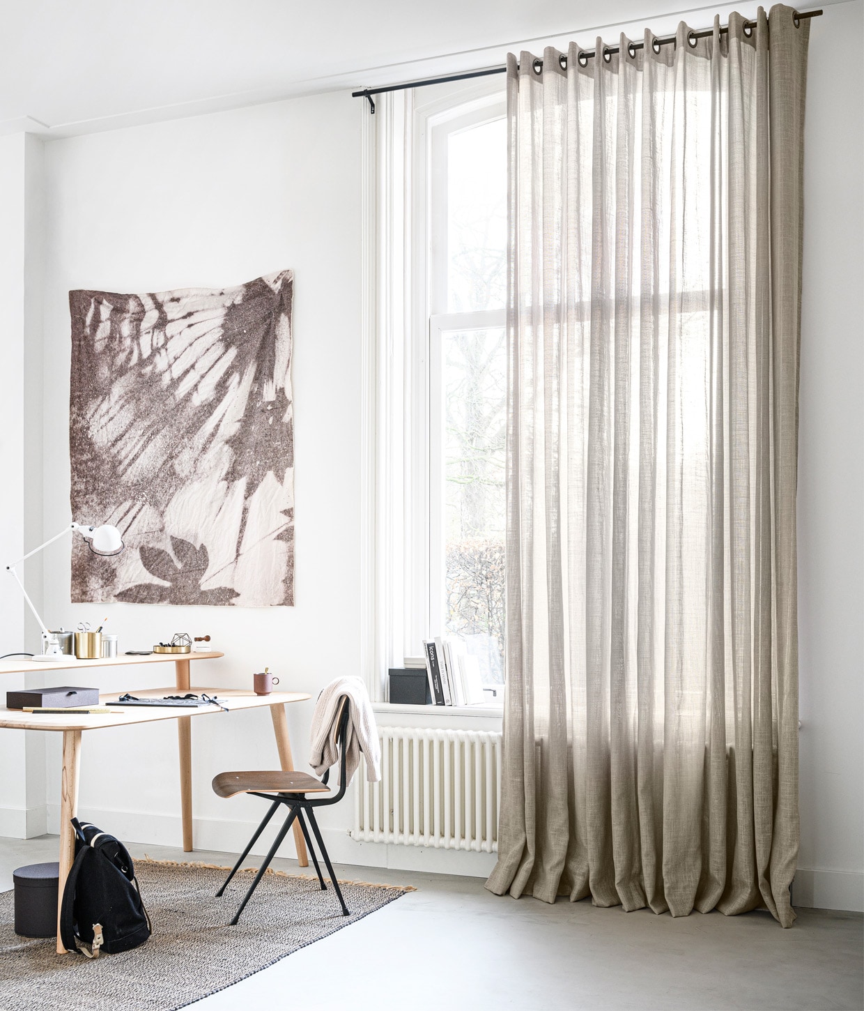 Gordijn in stof Vlas kleur 1150. M.m.v. demachinekamer.nl (bureau Olger van Sav &amp; Økse), blooming-label.com (wandkleed Quiet Resource), loods5.nl (stoel Result van Hay, gouden opberger), extravert.nl (bureaulamp), ikea.nl (ronde doos, langwerpige doos, doos in vensterbank, blik met deksel), hkliving.nl (mok), studione9en.nl (wollen trui van Second Female), sandqvist.com (rugzak), , hm.com (vloerkleed). Overig privébezit. Productie Tanja Saarberg | styling Marlies Does | fotografie Sjoerd Eickmans