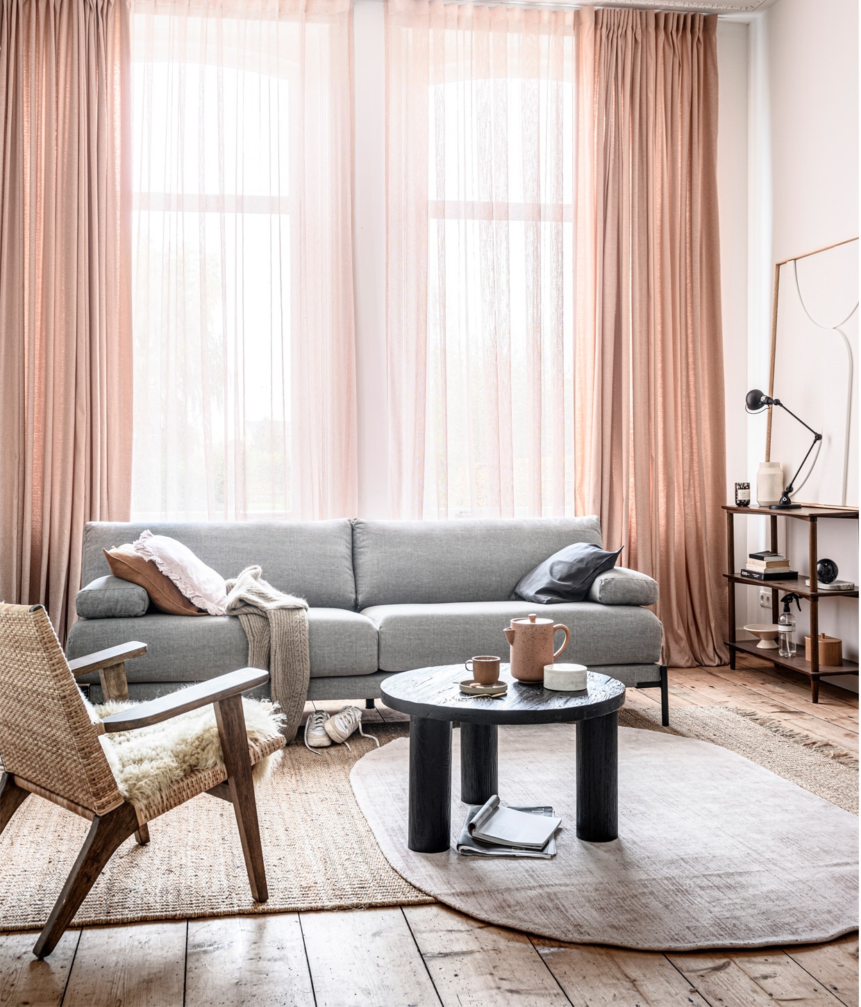 Gordijn op maat (2x) in stof Tweed met Wave plooi kleur 1147. Transparant gordijn op maat in stof Weave kleur 2713. M.m.v. hkliving.nl (fauteuil, vloerkleden, baklijst met artwork, schaal op voet, kist van hout), basiclabel.nl (bank Sleeve van vtwonen), loods5.nl (salontafel, kast, mok, theepot), hm.com (kussens op bank, wollen trui, marmeren opbergdoos, marmeren bal, glazen windlicht), extravert.nl (Jieldé lamp), marie-stella-maris.com (roomspray), adidas.nl (sneakers). Overig privébezit.