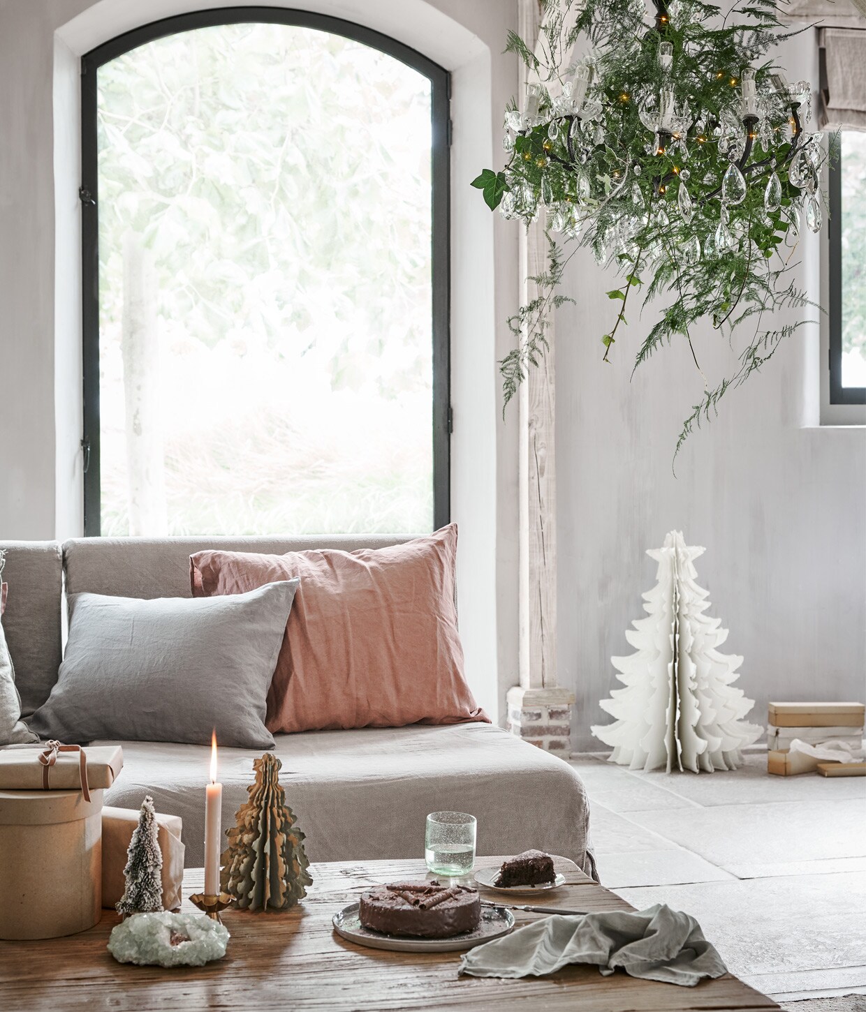 Kroonluchter € 195,- (jolandelijk.nl). Grote papieren kerstboom van Madam Stoltz € 41,50, glas van Nordal € 7,75 (deens.nl). Kandelaar € 5,95 (weldaad.com). Besneeuwde kerstboom € 4,99, lichtsnoer € 2,69 (intratuin.nl). Zachtgroene kussensloop 50×60 cm € 39,95, zalmroze kussensloop 60×70 cm € 45,95 (yumeko.nl). Kristal en dozen privébezit.