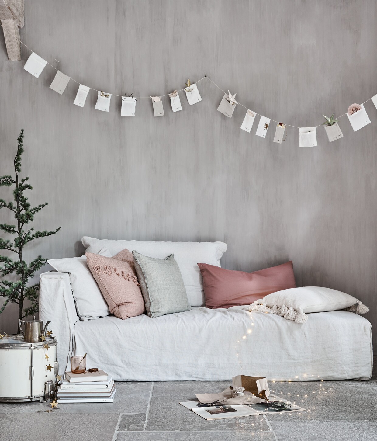 Sofa, soortgelijk: Ghost 20L van Paola Navone € 2526,- (gervasoni1882.it). Theepot € 19,- (jolandelijk.nl). Boom ceder, glas van Nordal € 7,75, roze kussen met franje € 55,25, wit kussen met kwasten € 34,50 (deens.nl). Zachtgroen kussen van Bungalow € 61,- (scandicliving.nl). Sterrenslinger € 22,50 (weldaad.com). Lichten aan draad € 2,69 (intratuin.nl). Katoen-satijnen kussensloop in blush rose € 25,95 (yumeko.nl). In de slinger, van links naar rechts: ster uitvouwbaar € 2,29 (intratuin.nl). IJzeren ster € 2,50 (weldaad.com). Nude hanger per 2 € 8,-, uitvouwbare ster per 3 € 11,75, goudkleurige hanger per 2 € 17,-, witte ster per 3 € 11,75, nude hanger van Bungalow, per 2 € 8,- (scandicliving.nl).