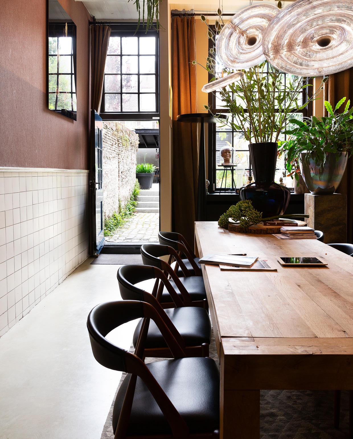 Overal in het huis zijn de handgemaakte potten van Ecri te vinden. Toen Gerwin nog in Italië woonde, had hij in Verona zijn eigen bloemenzaak, waar hij potten van dit merk verkocht. Tafel van Linteloo. De stoelen zijn vintage, en liet Dennis overkomen uit Denemarken. De zwarte designlamp van Prandina kocht Dennis voor een kopje op marktplaats.nl. Vloerkleed uit Alexandrium. vtwonen 1-2020 | styling Frans Uyterlinde | fotografie Jansje Klazinga | tekst Anne van den Dool