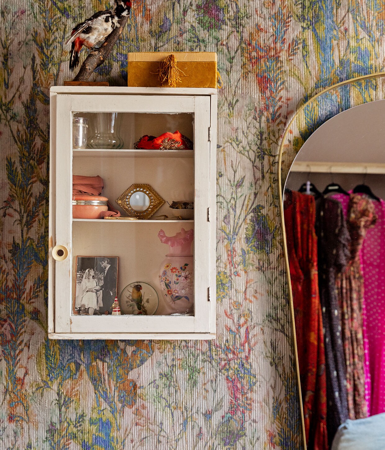 Behang Arte Walls, wandkast waarschijnlijk via Van Dijk &amp; Ko, spiegel Westwing. Items in kastje: trouwfoto in een messing lijstje van De Weldaad, zilveren geboortebeker van Vito, roze sieradendoosje van keramiek cadeau gekregen, oranje haarband van Antropologie, doosje op het kastje A La, vogeltje van een rommelmarkt. vtwonen 11-2020 | Productie en styling Ilona Jongepier | Fotografie Dana van Leeuwen | Tekst Anna van der Heijden