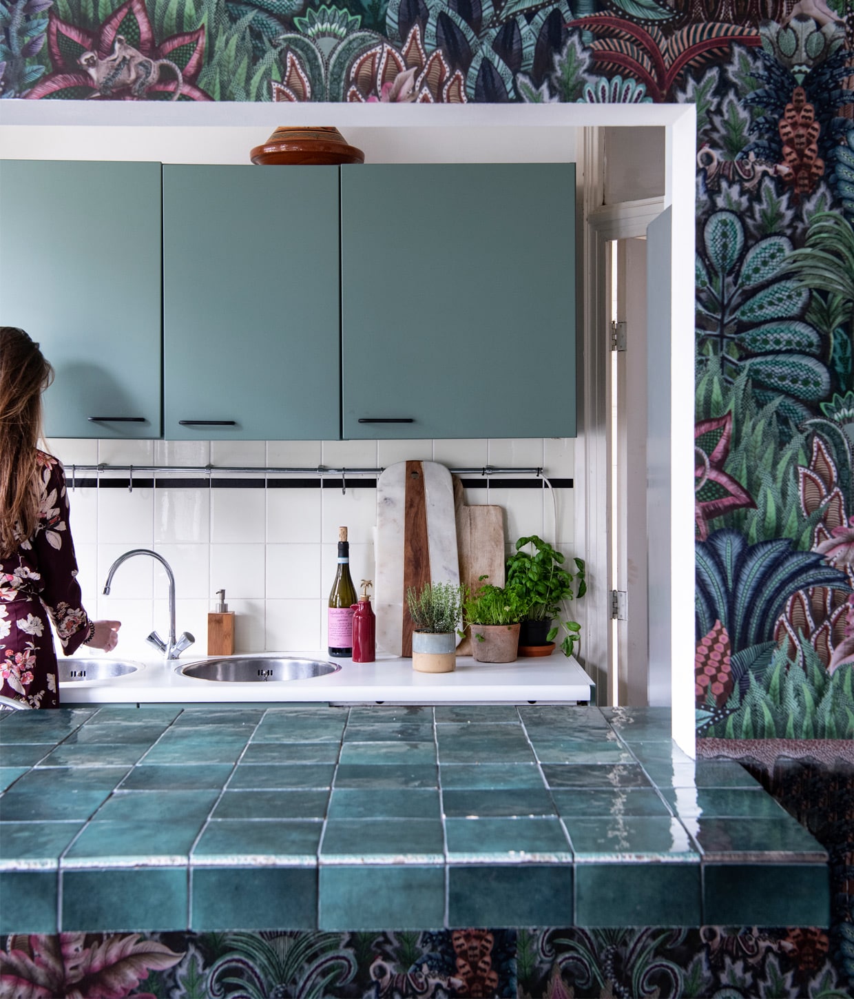De bar zat er al, Evy heeft hem zelf betegeld. Groenetegels van Tegels in huis, grote snijplank Woonfabriek(winkel bestaat niet meer), kleinere snijplank BloomingInterior. Behang Cole &amp; Son. Herkomst zeeppomponbekend. Verf op keukenkastdeuren Card Room GreenNo. 79 van Farrow &amp; Ball.