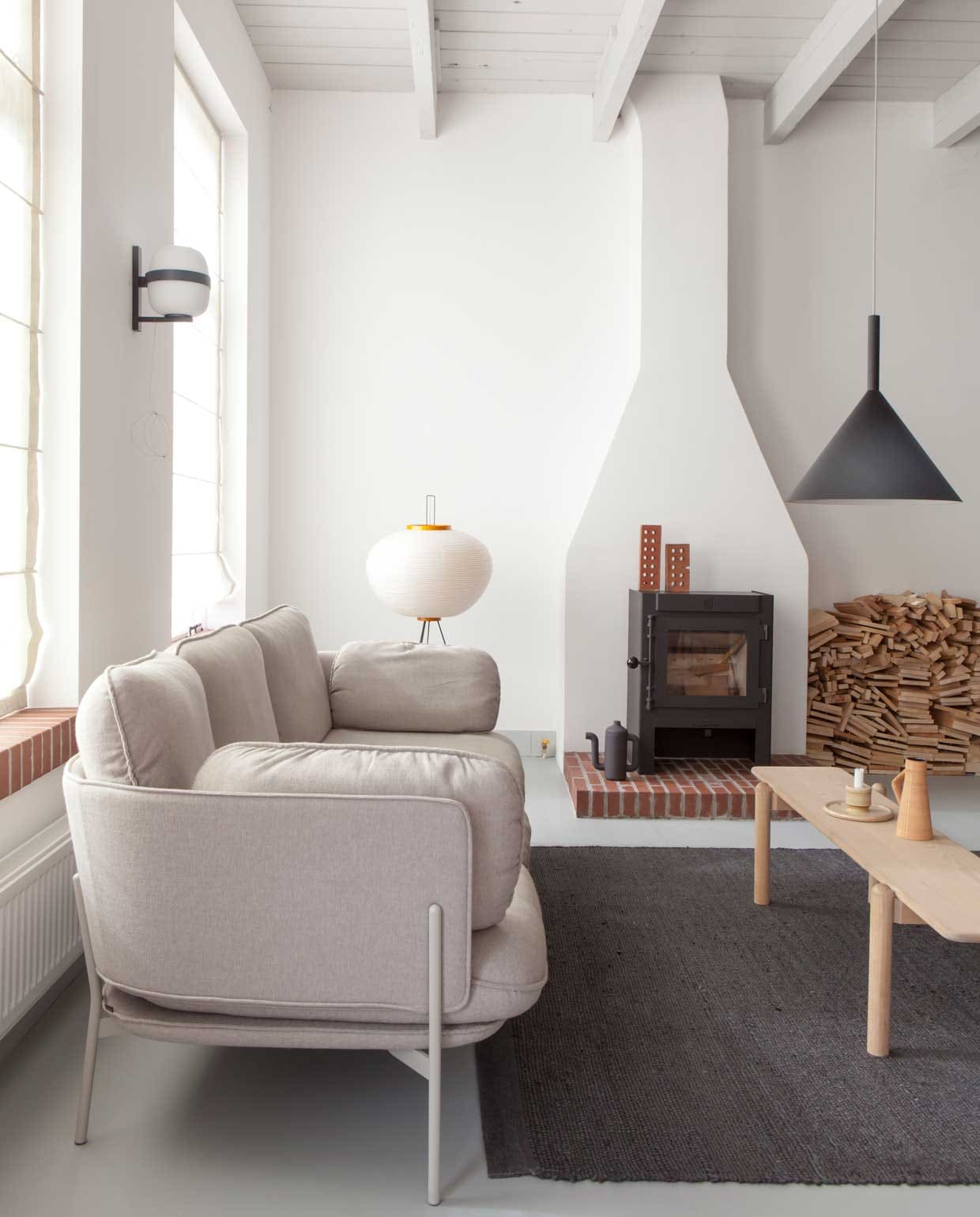 Rechterdeel van de woonkamer in het voorhuis. De schouw is origineel, kachel Dik Geurts. Vloerkleed Nanimarquina, salontafel SlowWood. Voor het raam Cloud Sofa van &amp;Tradition. Wandlamp Santa &amp; Cole, hanglamp Vertigo Bird, staande lamp Akari Light Sculpture van Isamu Noguchi (Vitra). vtwonen binnenkijken special 03-2020 | productie Taverne Agengy | fotografie Anna de Leeuw | Amber van Run