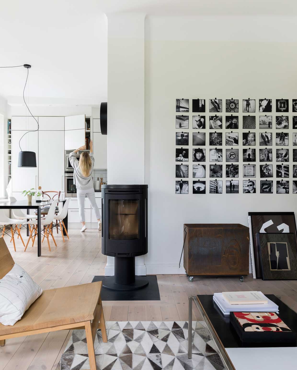 Stoel Ethnicraft, kussen H&amp;M, papieren lamp , Ikea, XL-meetlat en kast kringloop, zwart sculptuur Pepe Heykoop, kandelaars Granit, houten kantoorstoel van Harolds vader, washi tapekunst van Camilla. Kleed Bolia, puzzelbox Miller Goodman, tafel Kartell, stoelen Vita, hanglamp Vipp, kachel Jøtul.