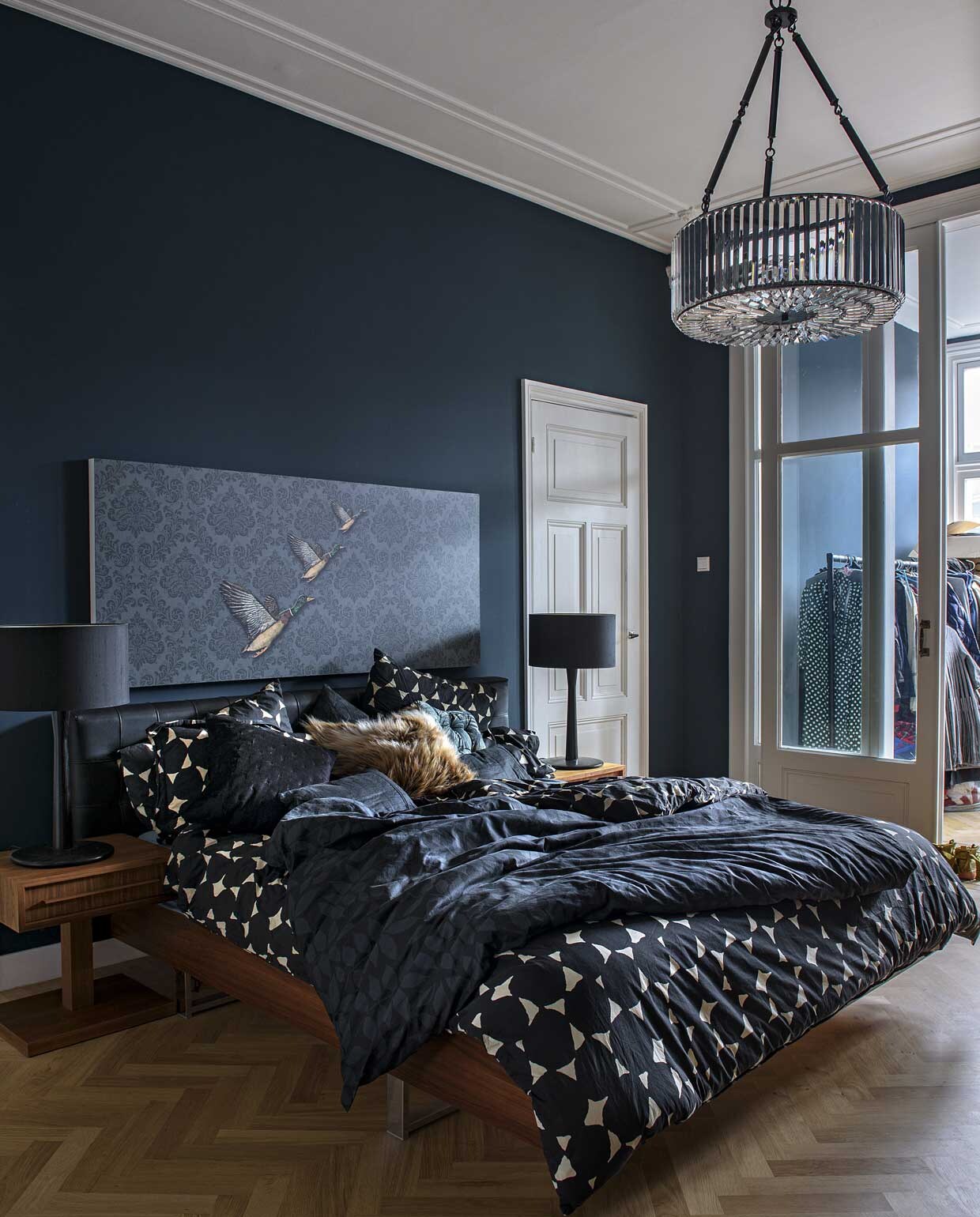 Muurverf in de master bedroom en badkamer Hague Blue van Farrow &amp; Ball. Bed, hoofdbord en nachtkastje Heal’s, lamp Habitat, beddengoed Hobbs. Kussens H&amp;M Home, Hobbs en Zara Home. Ornament met eendenprint van Spitalfields Market Londen.
