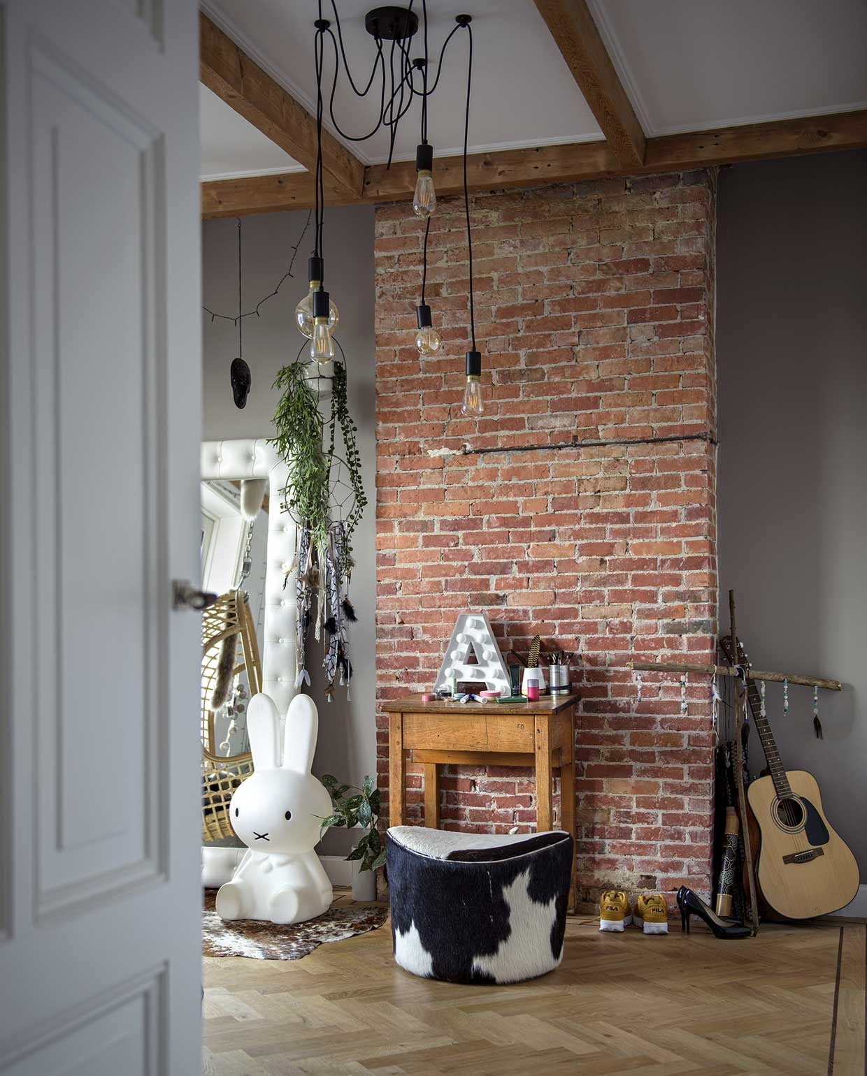 Bakstenenmuur via Reclaimed Brick Tile. Frans-eikenhouten visgraatvloer via aannemer Buijs Onderhoud. Beddengoed H&amp;M Home, hangstoel en plafondlamp Fonq. Spiegel met leren lijst Heal’s. Nijntje-lamp Mr. Maria. Kruk Ikea, herkomt plaids en vachten onbekend. , Tafel kringloopwinkel.