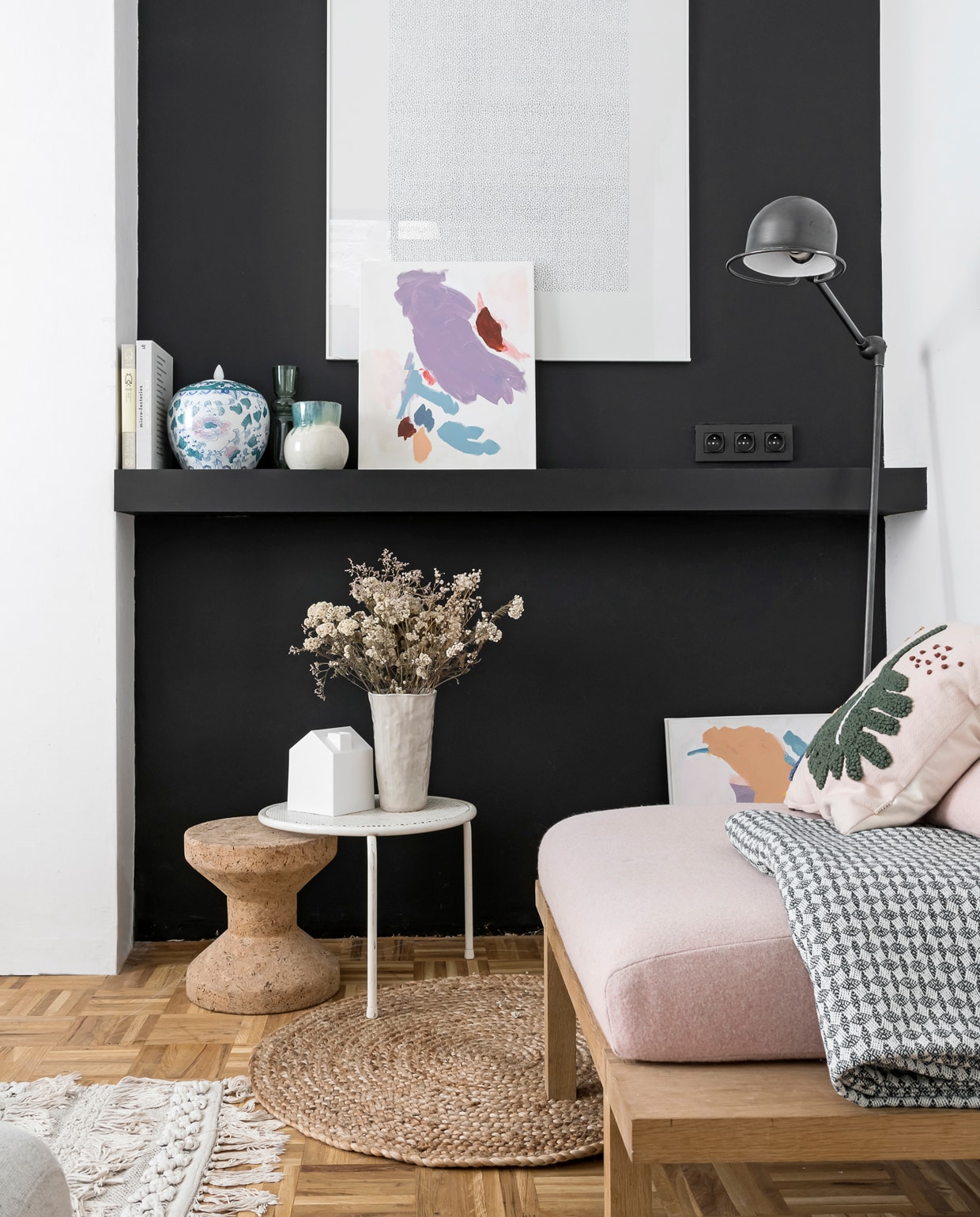 De fauteuil is door William gemaakt, zitkussens gestoffeerd door Atelier Denis. Kussen met blad Ferm Living, plaid Ikea. Op de zwarte muur hangen een werk van Guy de Cointet (een print van het originele magazine, gratis uitgegeven in 1971) en een schilderij dat Liene maakte. De bijzettafel is een brocante vondst. Kurken kruk van Vitra. Vazen van de kringloop. Wit huisje Umbra. Juten vloerkleed House Doctor, andere van een tweedehandsmarkt. Lamp Jieldé.