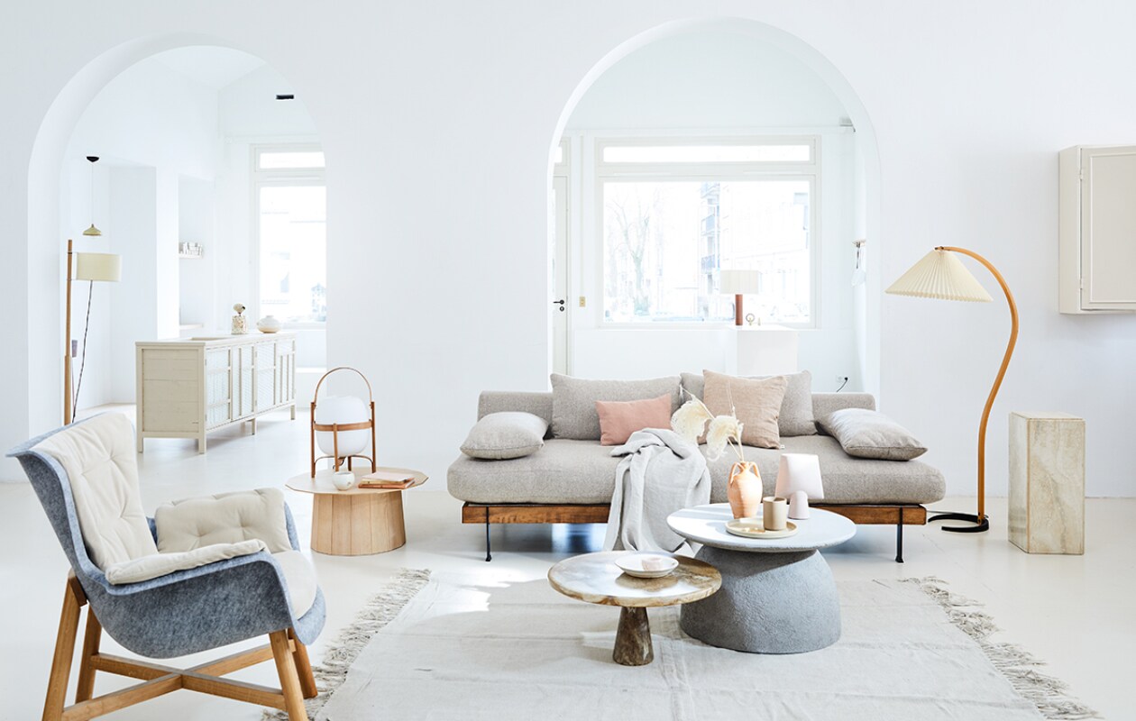 Staande lamp links van Santa &amp; Cole, pilaar Travertin Vintage, staande vintage lamp, beker van Hasami Porcelain, bord van Hasami Porcelain, messing schoteltje, diep bord van keramiek van Takashi Sogo, salontafel links van Karimoku New Standard, tafellamp van Santa &amp; Cole, schaaltje van keramiek Takashi Sogo (pantoufle-design.nl). Bank exclusief stof van l’Authentique (viavia-gorssel.nl). Betonlook bijzettafel (casagitane.com). Lage bijzettafel van gerecycled plastic van Dirk Vander Kooij (frozenfountain.nl). Roze handgemaakte vaas van keramiek (101cph.com). Marmeren bakje (stonedmarble.com). Linnen vloerkleed van HK Living (vtwonen.nl). Grijze fauteuil van gerecyclede petflessenflessen (demachinekamer.nl). Kussens Pink Salt van biologisch linnen, linnen plaid (bymölle.com). Kruikvaas en boeken privébezit. vtwonen 05-2019 | Styling Cleo Scheulderman | Fotografie Jeroen van der Spek