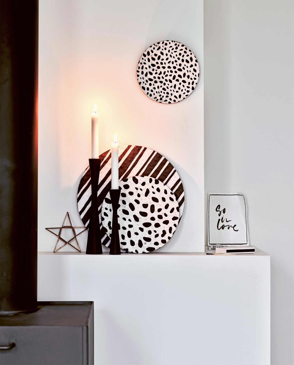 Papier-maché bord met zwarte strepen, papier-maché bord met zwarte stippen , en papier-maché bord met zwarte stippen. Zwarte, metalen kandelaar hoogte 30 cm (ook verkrijgbaar in 25,5 cm en 16 cm). vtwonen
