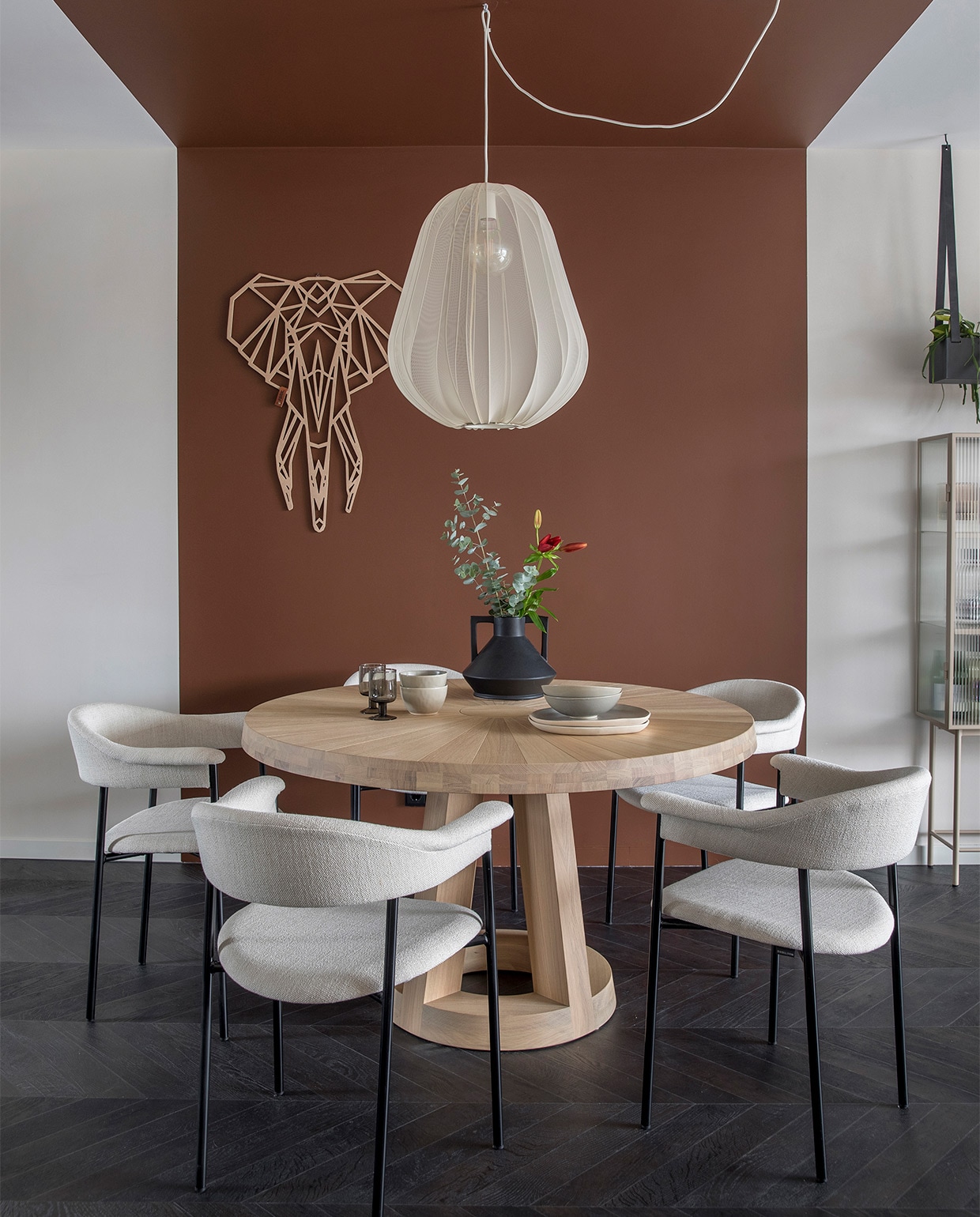 Vloer pvc met Hongaarse punt Moduleo Moods Chevron in kleur Impress Country Oak 54991 prijs op aanvraag (woninginrichting-aanhuis.nl). Flexa Creations muurverf Farmers Milk, kleurvlak Daring Sienna (flexa.nl). Gordijnen van stof Makalu 7002-12, ca. 300 cm (l), per meter € 64,95 (eijffinger.com), op maat gemaakt prijs op aanvraag (gordijnprodukties.nl). Radiatorbekleding Solid in de kleur RAL 9001 € 274,- (sentimo.nl). Kunstwerk Cirkel van Pieter Hogenbirk € 438,- (werkaandemuur.nl). Houten wandolifant Fabryk Design € 111,95 (abeltosh.com). Bank Pien € 3179,-, vloerkleed Barrax Brinker € 1499,-, eettafel Solid Odesi € 2795,-, eetkamerstoelen River Bodilson, per stuk € 309,-, kast Haze Ferm Living € 1489,-, plaid Leeff € 49,99 (eijerkamp.nl). Salontafel Ferro € 549,- (robuustetafels.nl). Hanglamp Bolia € 469,-, vloerlamp van Lucide € 94,95 (vtwonen.nl). Zwarte kraan CA106BK ECO, zwarte spoelbak CAGR50KRBK-TU prijs op aanvraag (caressi.nl). vtwonen Weer verliefd op je huis | seizoen 14, aflevering 4 | styling Eva van de Ven | fotografie Margriet Hoekstra