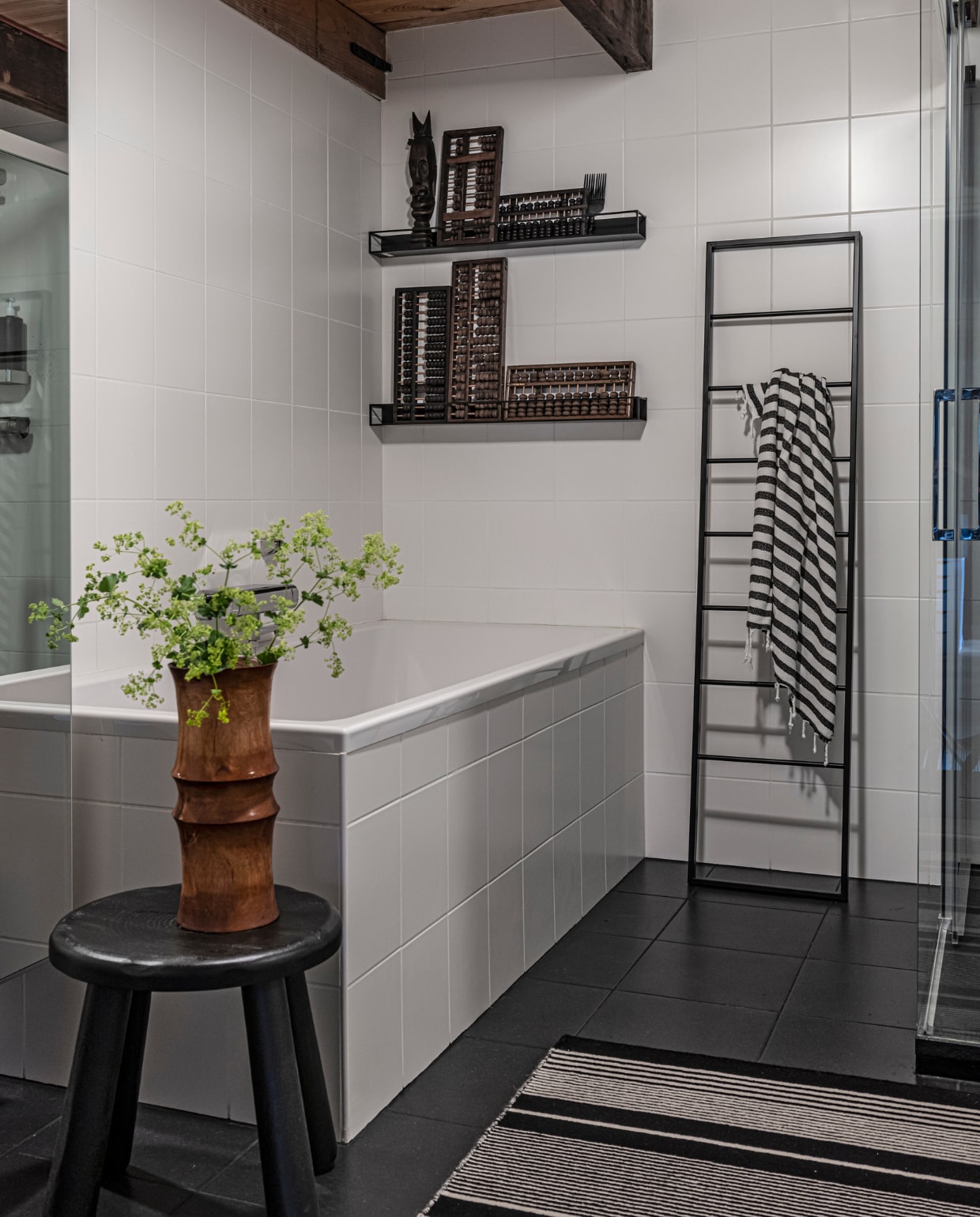Een basic badkamer krijgt karakter door bijzondere objecten en , reissouvenirs toe te voegen. Zoals , hier antieke telramen uit Shanghai en een bamboe vaas van de kringloop. vtwonen binnenkijkspecial 12-2020 | styling Sharon Roest | fotografie Caroline Martinot