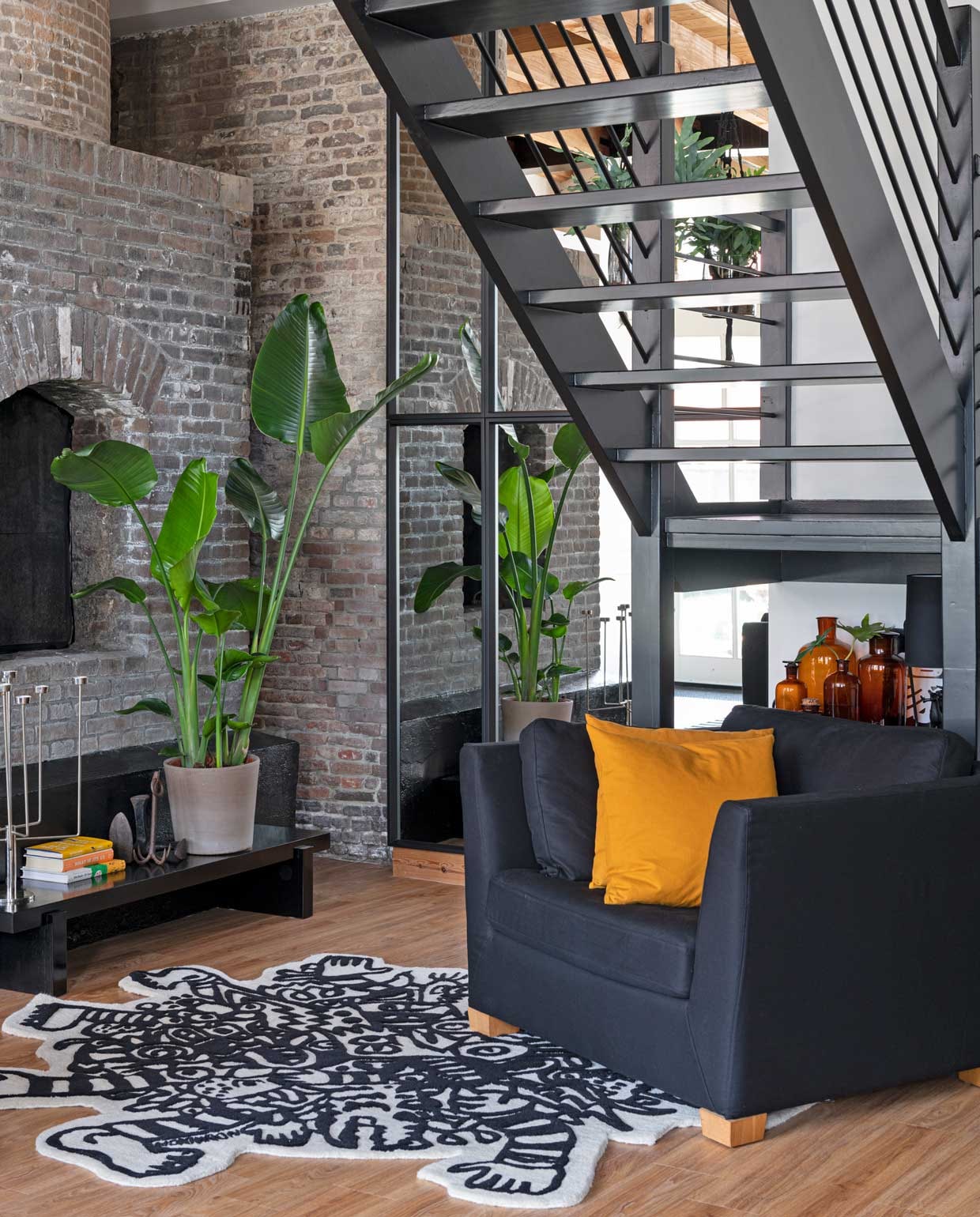 Fauteuil, vloerkleed en zwartgeverfde tafel Ikea. Anker van rommelmarkt, kandelaar Habitat, kussen H&M Home, apothekers-flessen van Marcels moeder. Houten raamwerk met spiegelglas op maat laten maken. vtwonen binnenkijkspecial 12-2020 | styling Sharon Roest | fotografie Caroline Martinot