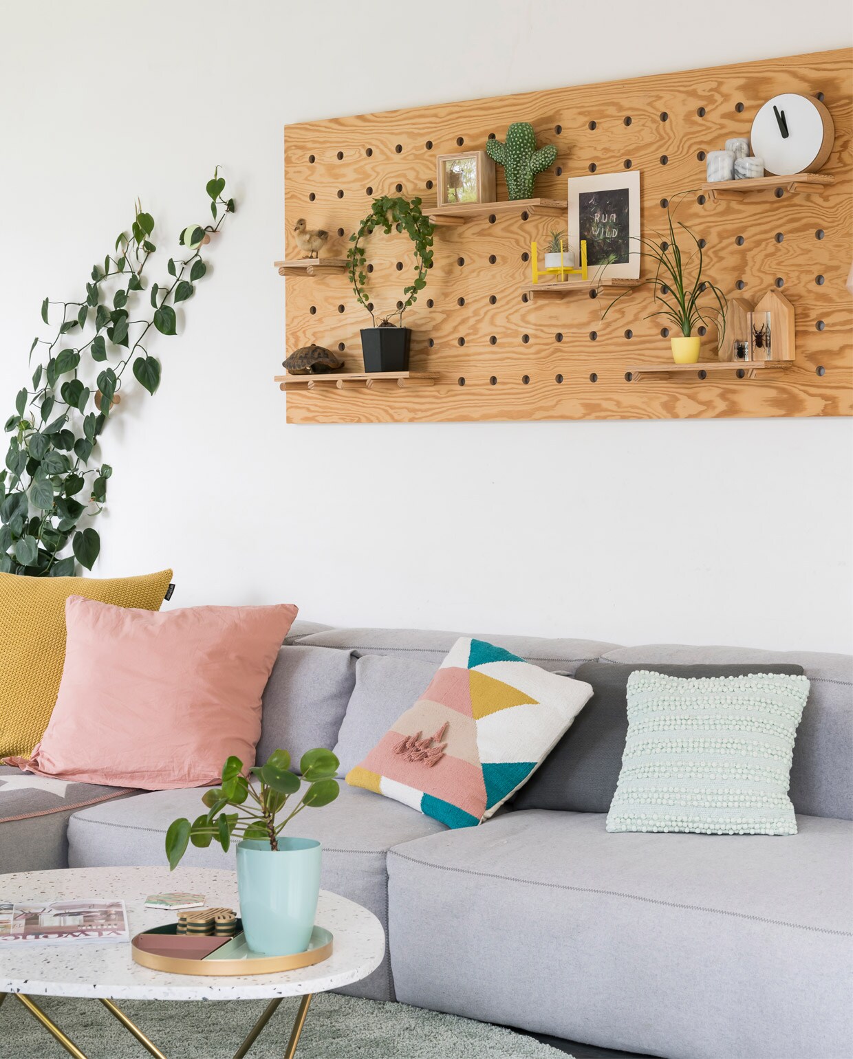 De stallen maakten plaats voor een ruime en lichte woonkamer met open keuken. Pegboard en schoolbord zelfgemaakt. Bank Mags Soft van Hay. Kussens Zodio, Action en Hay. Vloerkleed Ikea, salontafel Furnified. Houtkachel Aduro.