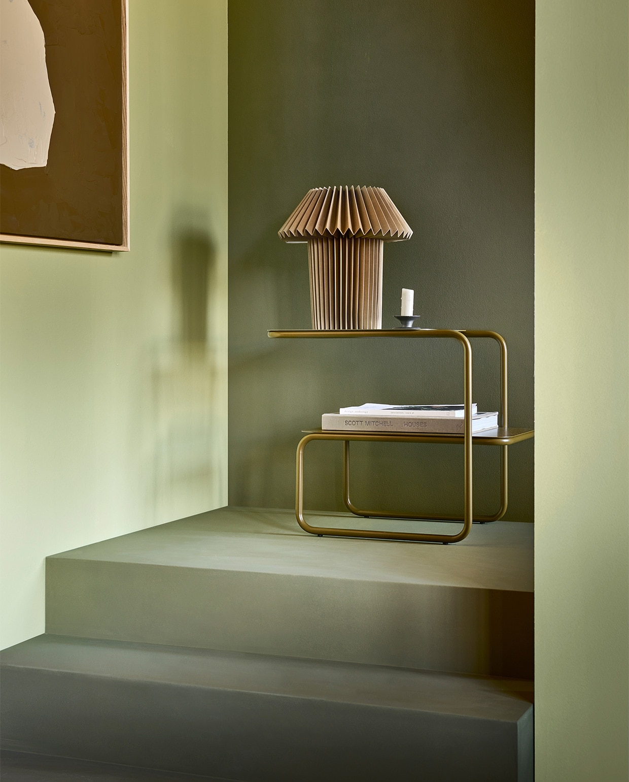 Muurverf linker wand en paal Fennel, trap en achterwand Khaki van vtwonen collectie, 1 liter € 23,99, 2,5 liter € 39,99. M.m.v. vtwonen.nl (donkergroene bijzettafel van Ferm Living), hm.com (papieren tafellamp), hkliving.com (schilderij). Overig privébezit. JA | vtwonen 01-2023 |  styling Sanne Ketelaar | fotografie Sjoerd Eickmans | productie Tanja Saarberg