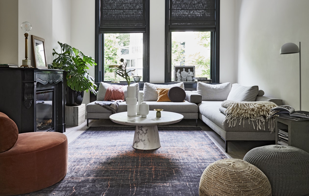 Bank Aikon Lounge, inclusief armsteun (designonstock.com). Vloerkleed van Louis de Poortere uit de serie Mad Men (vloerkledenwinkel.nl). Salontafel marmerlook, 40,6×100 cm (hxØ), rond kussen, goudkleurig velvet kussen (polspotten.nl). Loungestoel velvet, plaid , witte vaas met oor, kleinere vaas van Loods 5 Design (loods5.nl). Hoge vaas, staande lamp (hkliving.nl). Beige Poef Sandared, grijze poef, lijst Hovsta (ikea.nl). Lamp op marmeren schouw (maisonnl.com). Lamp in vensterbank (dutchbone.com). Vaas met oren (neeflouis.nl). Kandelaar op tafel (vtwonen.nl). Overigprivébezit.