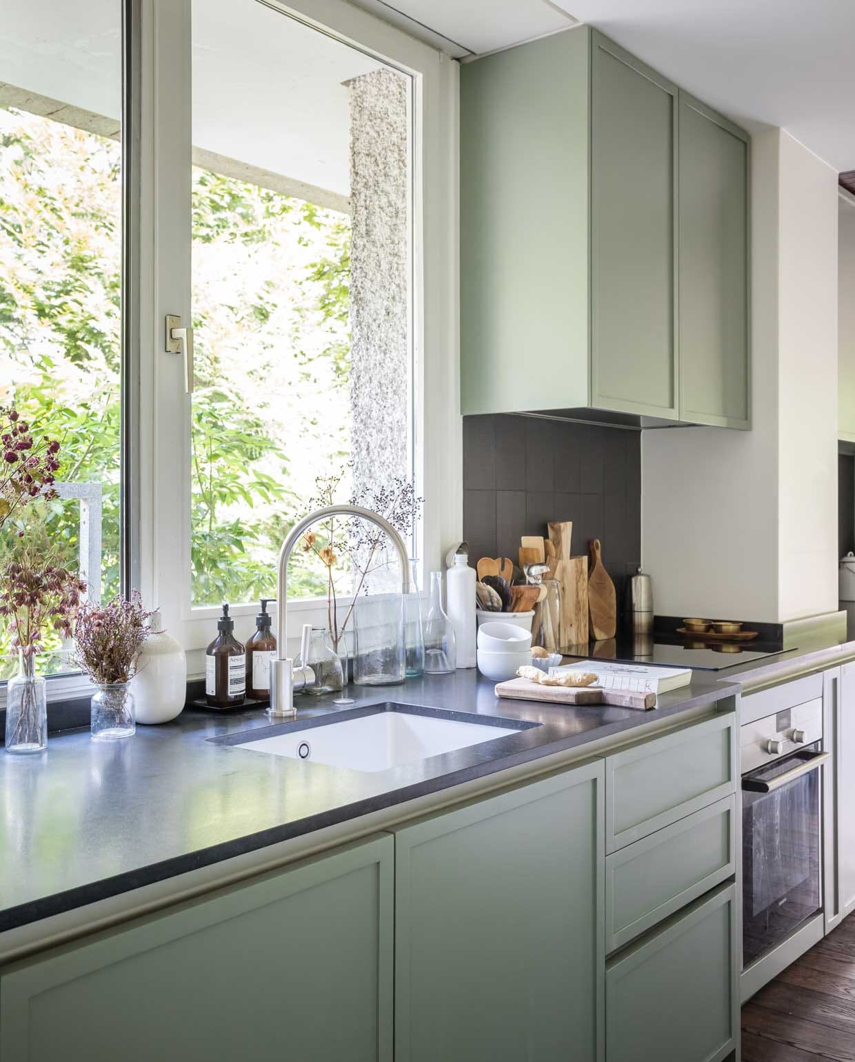 De op maat ontworpen keuken moest modern worden, maar niet te strak. De kastjes zijn geverfd in Card Room Green van Farrow &amp; Ball.