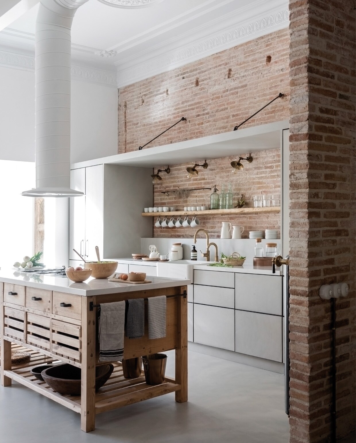Frontjes van de keuken zijn van microment, net als de vloer, marmeren aanrecht van Compac model Calacatta, kraan Neve, gaskookplaat Smeg, de afzuigkap is eigen ontwerp en op maat gemaakt, ladekastjes afkomstig uit het Indiase Rajasthan, ambachtelijke houten schalen en wit porselein werden her en der verzameld.