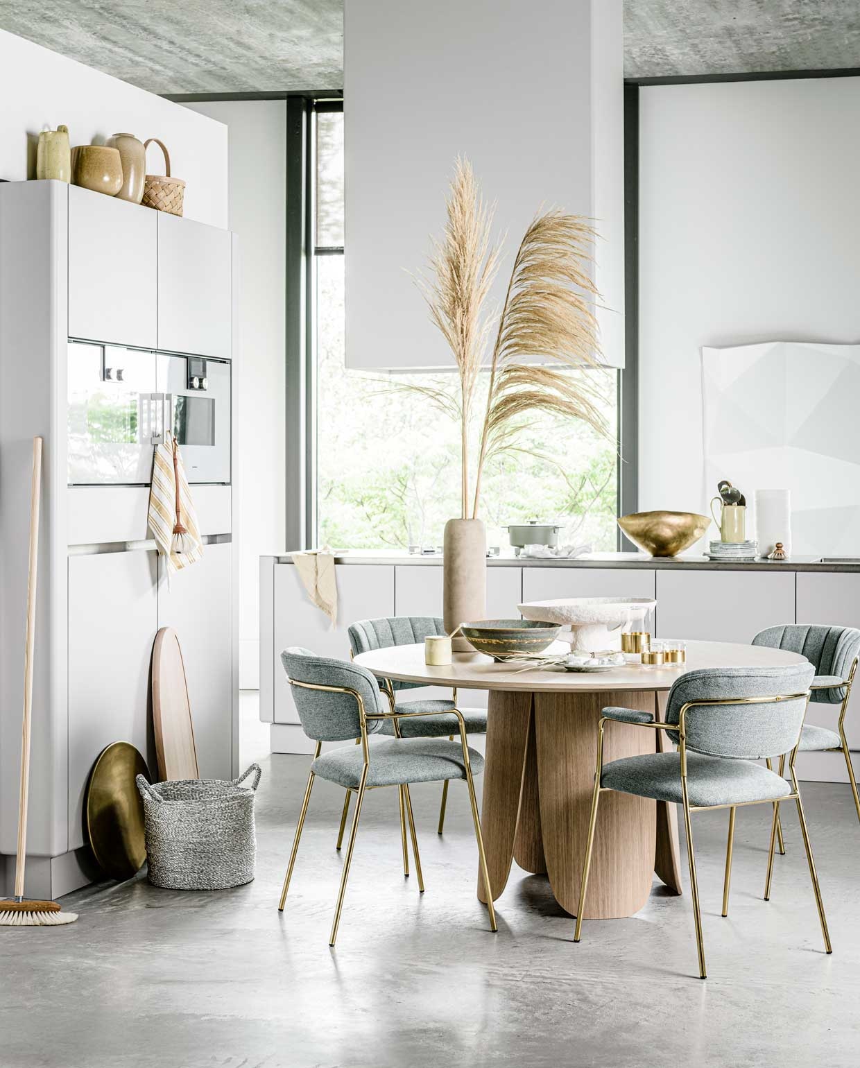 Stoelen Jolien, 49x56x79 cm (bxdxh), per stuk € 169,- (whatiship.nl). Ronde eettafel Peyote, 140×74,5 cm (Øxh) € 1599,- (bolia.com). Pluimen, prijs op aanvraag (greenlifestylestore.nl). Vaas op tafel € 40,- (loods5.nl). Groene serveerkom Pure L van Serax, Ø 32 cm € 79,- (bijenkorf.nl). Witte schaal € 139,-, glazen met gouden rand, per stuk € 17,50,-, glazen kan met gouden rand € 29,-, zilveren lepels in gele kan, per stuk € 29,- (serax.com). Groen met wit gevlekt bord klein € 15,-, groot € 19,- (hayonlinewinkel.com). Keuken Contour met keukeneiland vanaf € 27.500,- (pietboon.com). Geel bakje met lepel € 25,-, gele kan op aanrecht en keukenkast € 55,- (fermliving.com). Grote gouden schaal € 484,- (homestede.nl). Bezem € 48,50, afwasborstel € 20,50, stoffer € 31,- (pantoufle-design.nl). Groene kookpan Surface van Serax, 3 l € 145,-, houten serveerplank Timber van Salt &amp; Pepper, 80×25 cm € 52,99, gele gastendoek op keukeneiland Giant van Hay € 15,- (vtwonen.be). Zilveren mand € 27,95 (loods5.nl). Geel met wit gestreepte theedoek, set van 3 € 7,99, gele vazen op keukenkast per stuk € 14,99 € 14,99 (hm.com). Mand op keukenkast € 4,99 (sostrenegrene.com). Overig privébezit. vtwonen | styling Liza Wassenaar | fotografie Sjoerd Eickmans