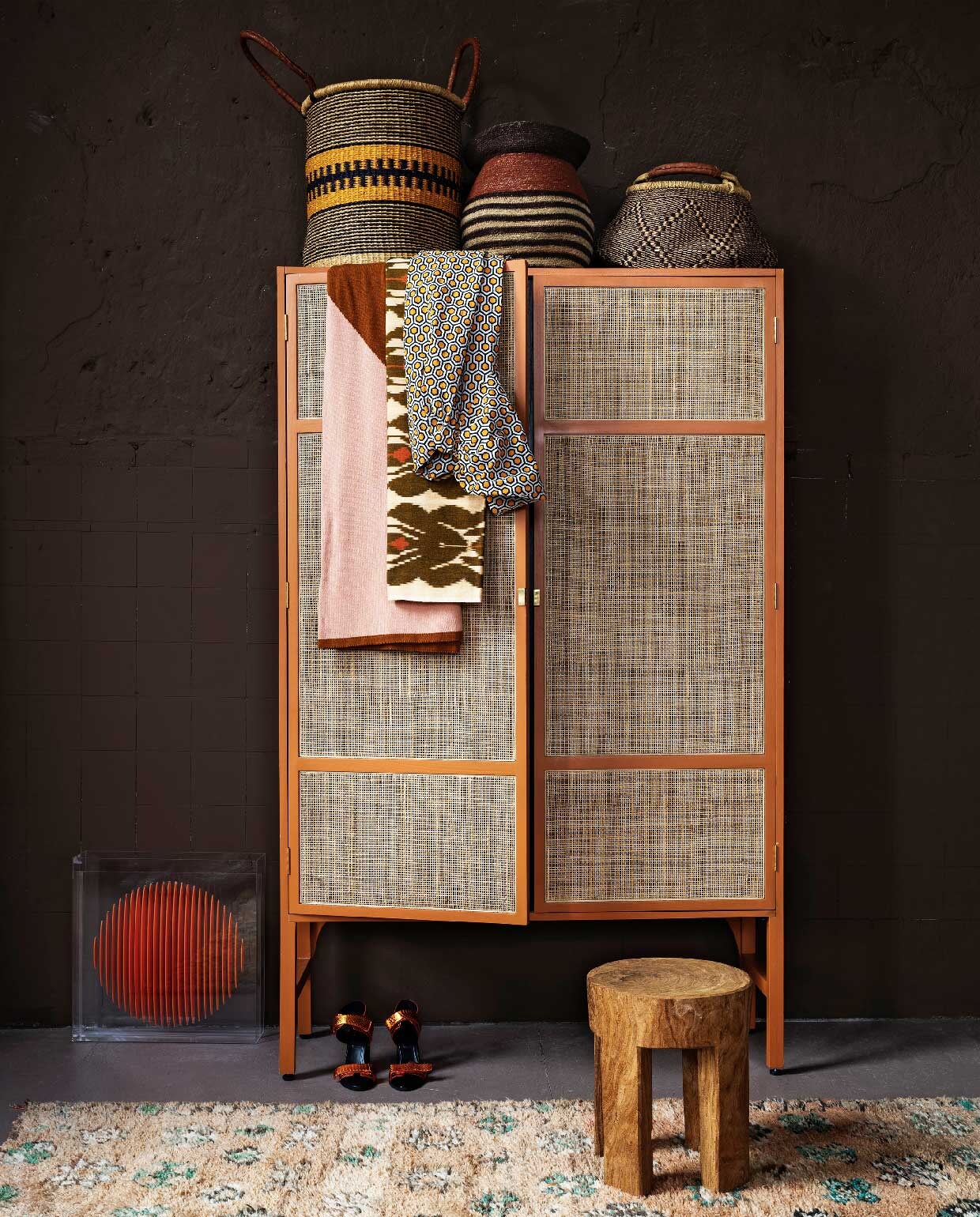 Op de muur krijtverf Brown Sugar, per liter € 39,30 (pure-original.nl). , Kast, 125x40x200 cm (lxbxh) € 1495,-, plexiglas kunst € 275,- (hkliving.nl). Oude berber, 150×270 cm € 595,- (rozenkelim.nl). Houten kruk vanaf, € 293,- (polspotten.nl). Grote mand, handgemaakt in Senegal, 80×48 cm (hxØ) € 109,50, kleine handgemaakte savannegras mand € 44,50 (basketbeadsbasics.nl). Mand midden van vtwonen € 49,95 (vtwonen.nl). Roze- , en toffeekleurig plaid van organisch katoen € 99,95 (suite702.com). Ikat stof, per meter € 40,- (capsicum.nl). Tuniek en schoenen (christianwijnants.com).