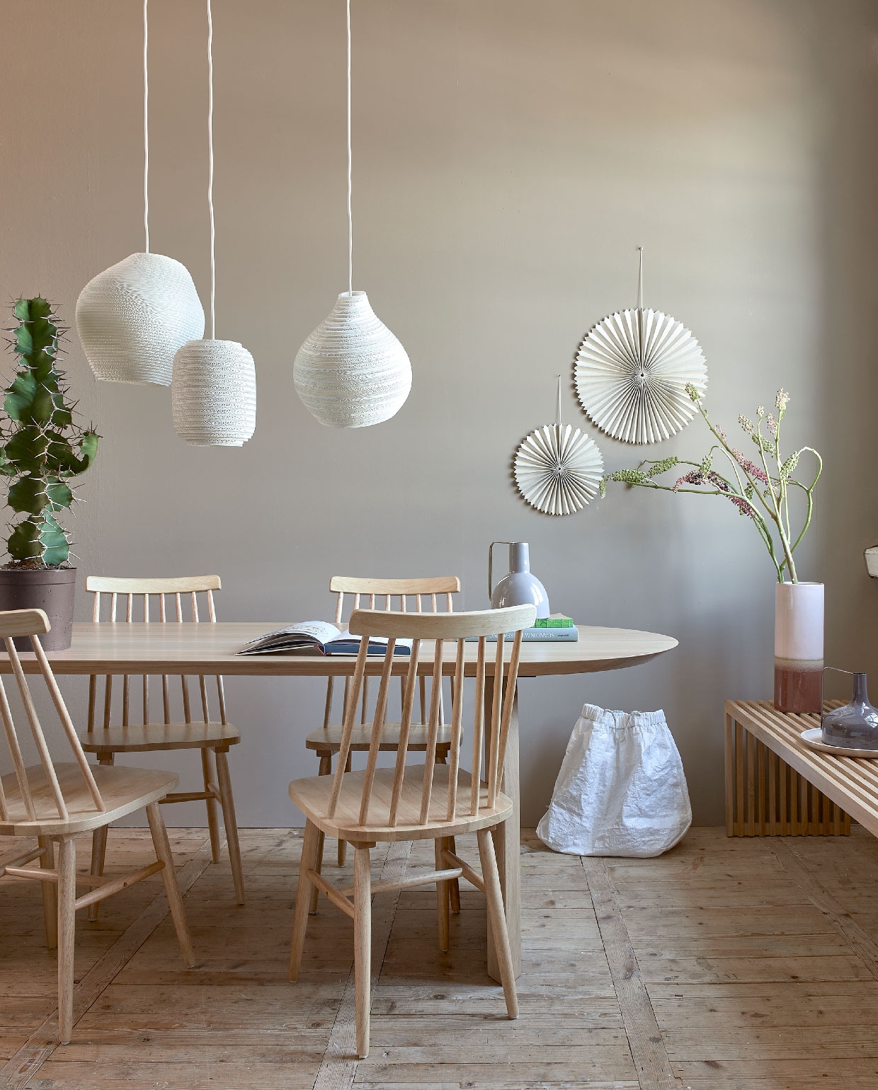 Muurverf Mire van vtwonen, per 2,5 l , € 32,99 (karwei.nl). Tafel Slot van Studio Henk, 220x90x74 cm (lxbxh) € 2975,- (eijerkamp.nl). Spijlenstoelen per stuk € 81,-, hoge vaas € 38,50, vaas met handvat vanaf € 29,95, houten bord , € 29,95 (vtwonen.nl). Lampen Graypants, per stuk vanaf € 245,- (vanmokum.com). Waaiers per stuk vanaf € 8,95, witte tas € 89,- (sukha.nl). Overig privébezit. vtwonen 10-2020 | styling Fietje Bruijn | fotografie Dennis Brandsma