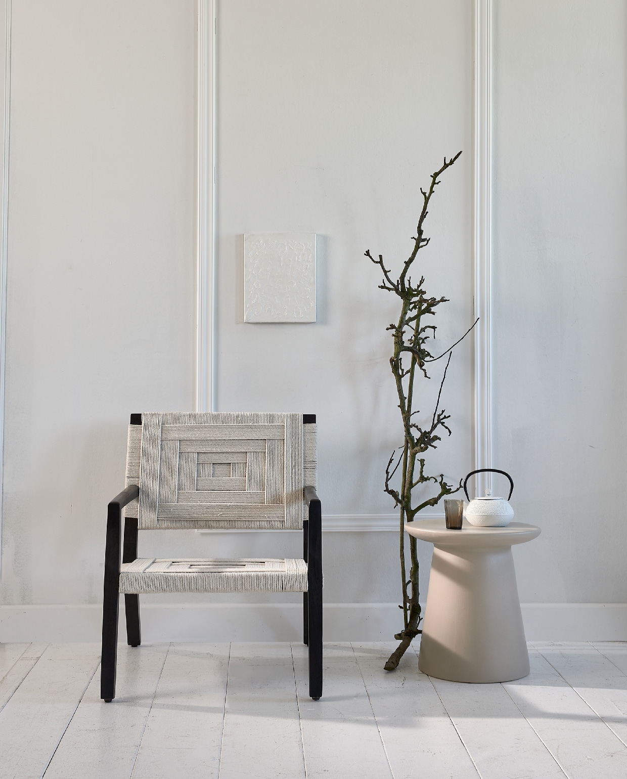 Stoel met gevlochten singels Shima € 272,- (eijerkamp.nl). Keramische tafel € 195,- (hkliving.nl). Japanse theepot € 25,-, grijs geribbeld glas € 3,50 (loods5.nl). Kunst prijs op aanvraag (atolty.com). Lijsten via bouwmarkt. vtwonen 10-2020 | styling Fietje Bruijn | fotografie Dennis Brandsma