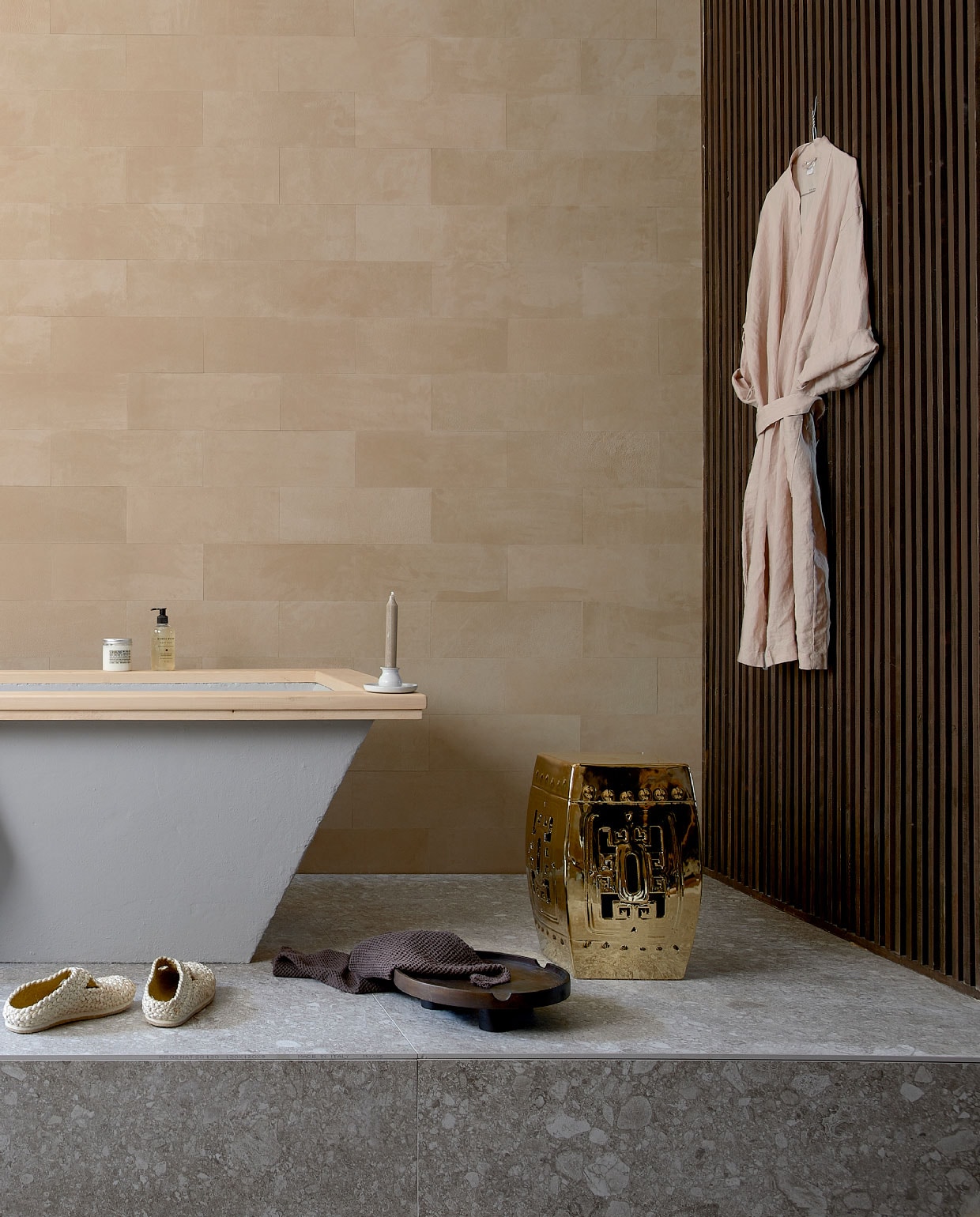 Leren wandtegels uit de Colorado collectie, kleur 3901 desert, als afgebeeld € 4500,- (ohmannleather.com). Podiumvloer met vloer-en wandtegel Composite Light Grey van vtwonen, 120×120 cm per m² € 79,95 (vtwonentegels.nl). Bad betonlook met houten rand, op maat gemaakt, prijs op aanvraag, lattenwand, prijs op aanvraag (com-anders.nl). Kraan Grip van vtwonen € 596,- (vtwonen.nl). Ecru handdoek € 14,99, schaal € 24,99, bruine handdoek € 5,99, linnen ochtendjas € 39,99 (hm.com). Schoenen € 105,-, (sukha.nl). Kruk Temple € 386,50 (polspotten.nl). Rieten mand € 22,50 (loods5.nl). Overig privébezit. JA | vtwonen 10-2020 | styling Fietje Bruijn | fotografie Dennis Brandsma