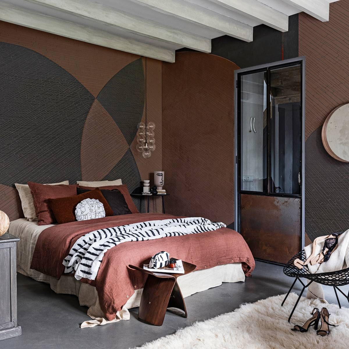 Behang Ego, per m² € 91,- (glamora.it). Spiegel Stockholm € 79,95 (ikea.com). Zwarte draadstalen stoel € 475,- (paullelieveld.com). Vloerkleed, 140×200 cm (lxb) € 268,- (therealrugcompany.co.uk). Zwarte wandtafel € 179,95 (loods5.nl/design). Vaas met geschilderd hoofd € 24,99, aardewerken kandelaar € 14,99, zwart vaasje € 7,99, geurkaars in bruine glazen pot € 4,99 (hm.com). Hanglamp van House Doctor € 89,85 (vtwonen.nl). Linnen dekbedovertrek in de kleur terra, vanaf € 139,-, linnen kussenslopen in de kleuren terra en wheat, per stuk € 28,-, linnen laken in de kleur wheat € 119,- (bymolle.com). Vierkant sierkussen van stof Georgetown 7716-6, per meter € 34,95 (eijffinger.com). Langwerpig sierkussen van teddystof Bolke Terra € 6,-, rond sierkussen gemaakt van stof Gina € 6,- (kwantum.nl). Sprei van stof Paris Lipari van Nobilis € 130,- (wva.nl). Bijzettafel € 795,-, toilettas € 50,- (coosdewitwonen.nl). Overig privébezit. vtwonen 03-2020 |  styling styling Danielle Verheul | fotografie Sjoerd Eickmans